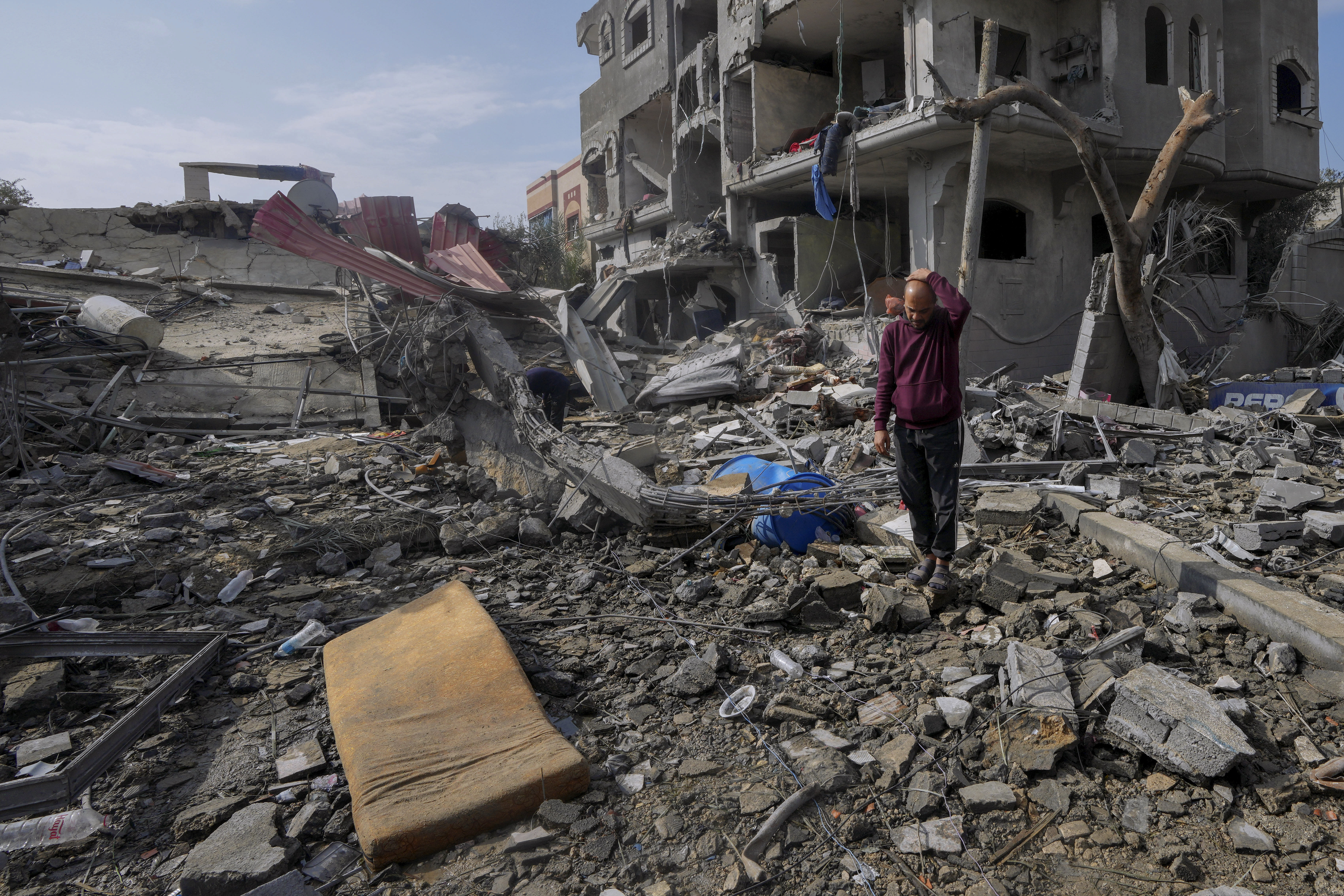 Palestinians inspect the rubble of a building of the Al Nawasrah family destroyed in an Israeli strike in Maghazi refugee camp, central Gaza Strip, Monday.