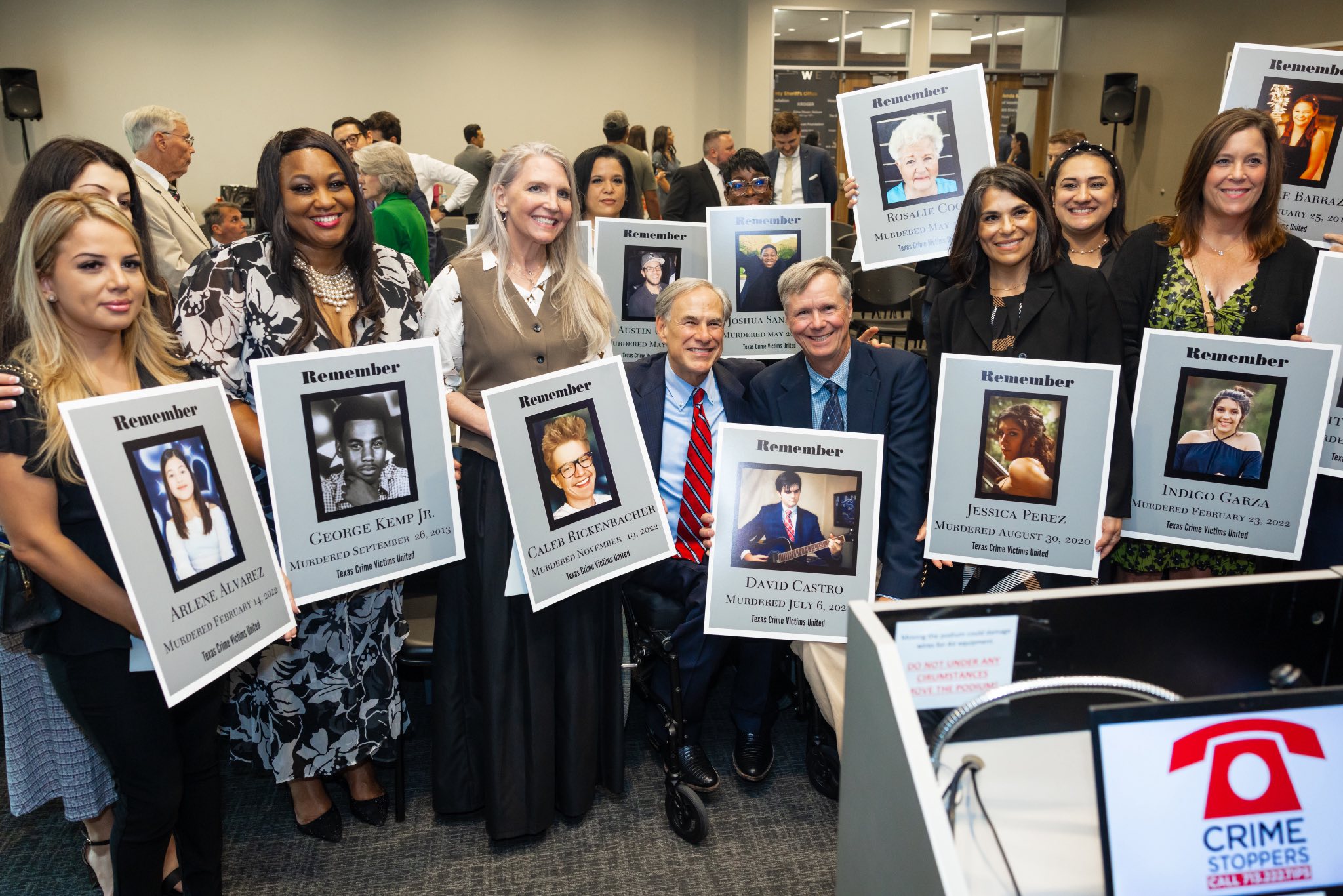 Abbott with victims families and pictures.jpg