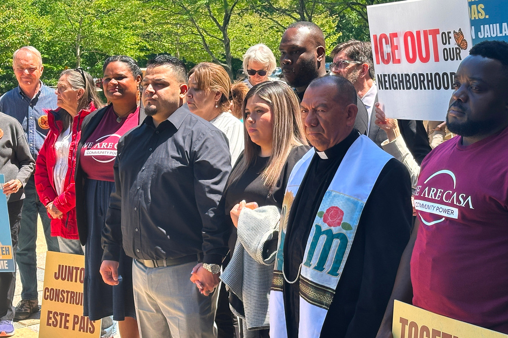 Kilmar Abrego Garcia and his wife, center, hold hands as people rally in support of him at a news conference outside federal court after a hearing in his case on Tuesday, May 12, 2026, in Greenbelt, Md. 