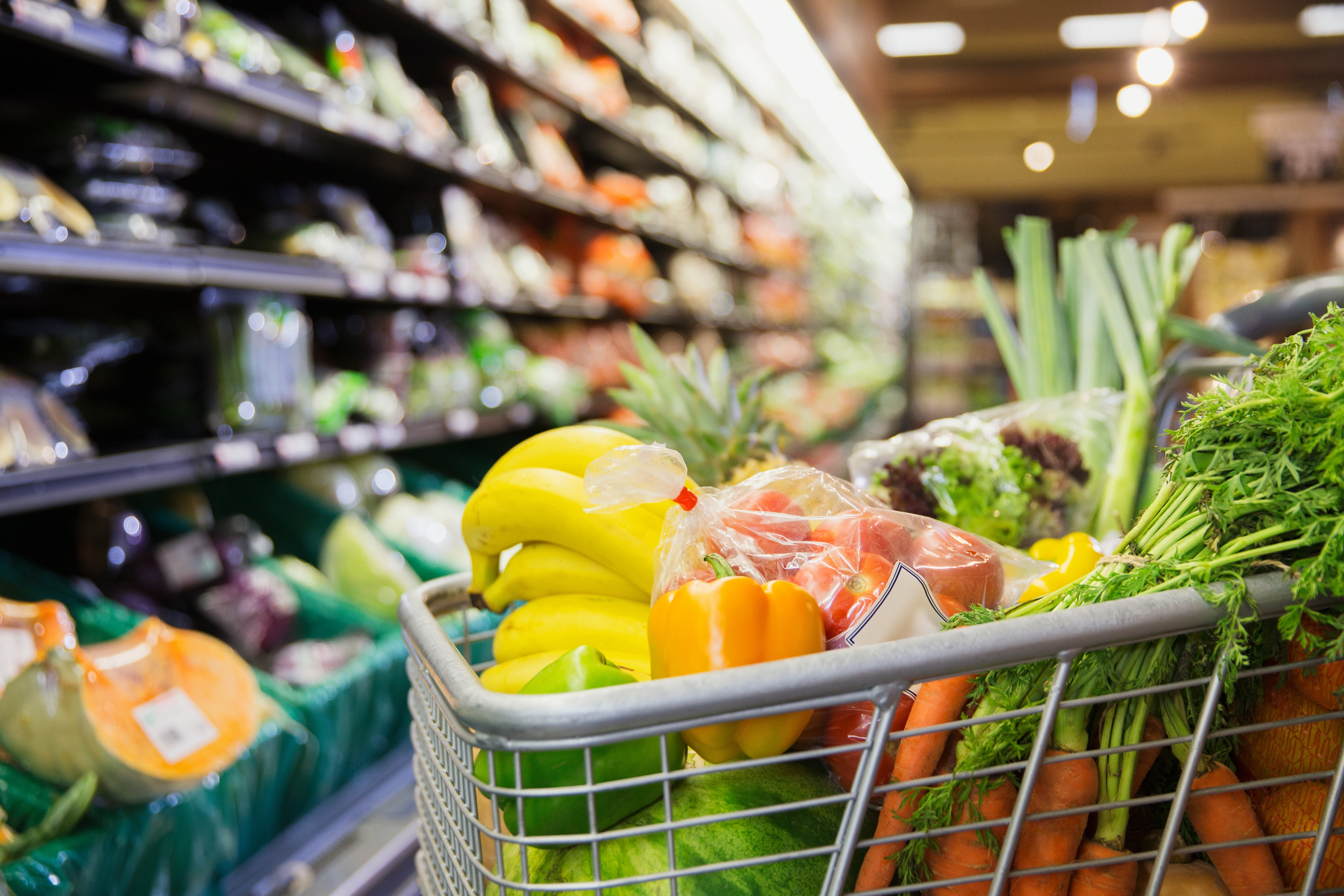 A shopping cart full of produce. 