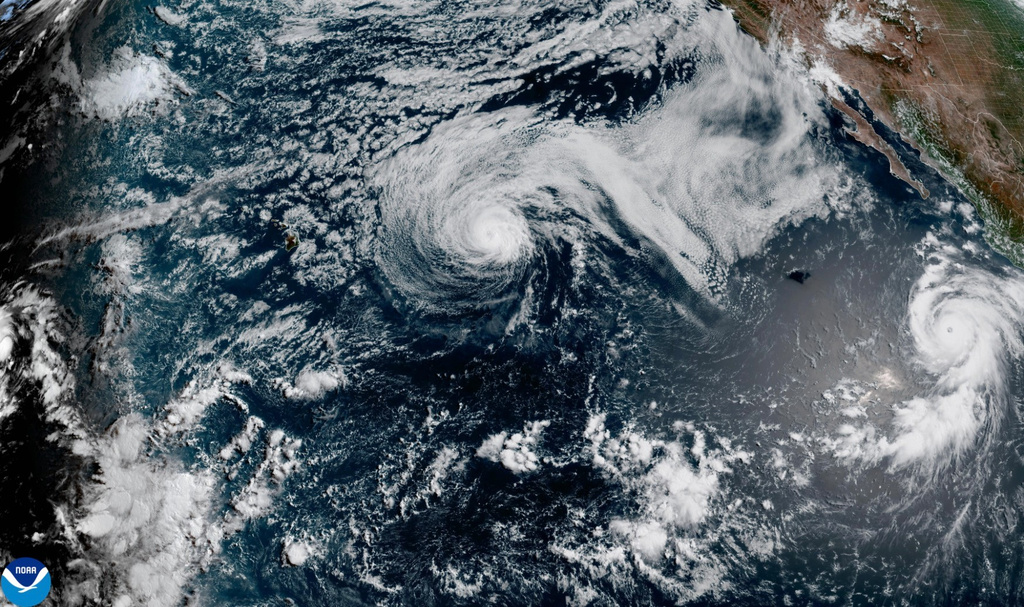 This satellite image released by NOAA shows Hurricane Fausto, center, and Hurricane Genevieve off the southwest coast of Mexico, right, over the Pacific Ocean, Sunday, July 26, 2026. 