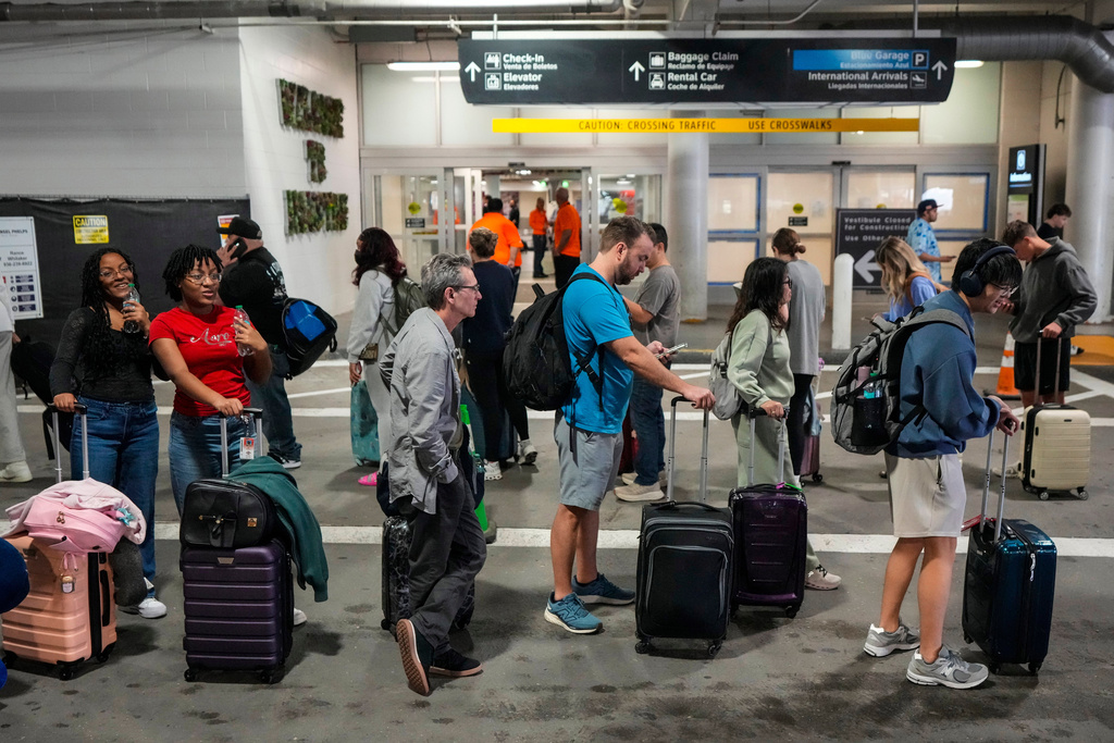 Airline passengers wait in long lines outside the terminal to get through the TSA security screening at William P. Hobby Airport in Houston, Sunday, March 8, 2026.