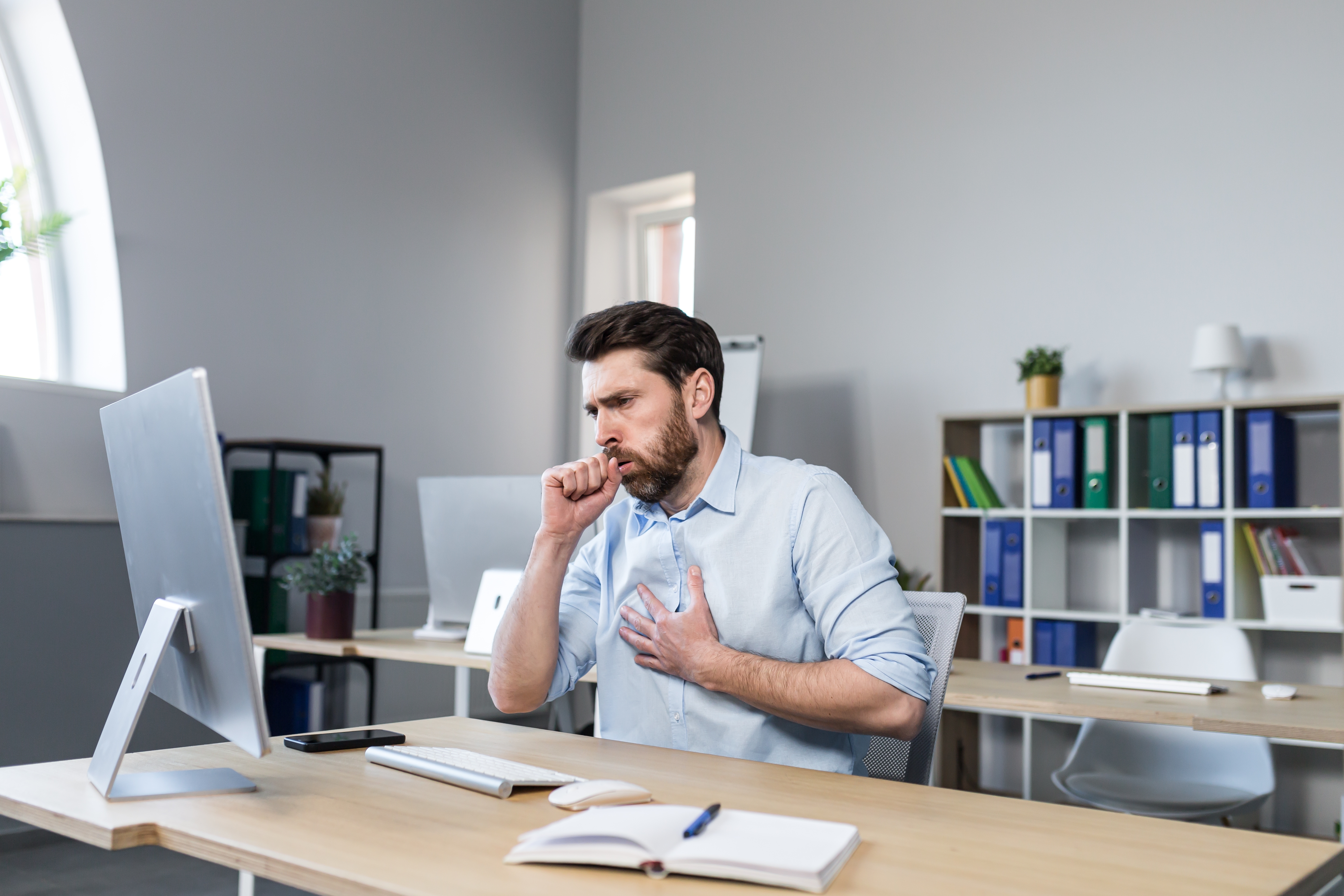 A man coughing while at work.