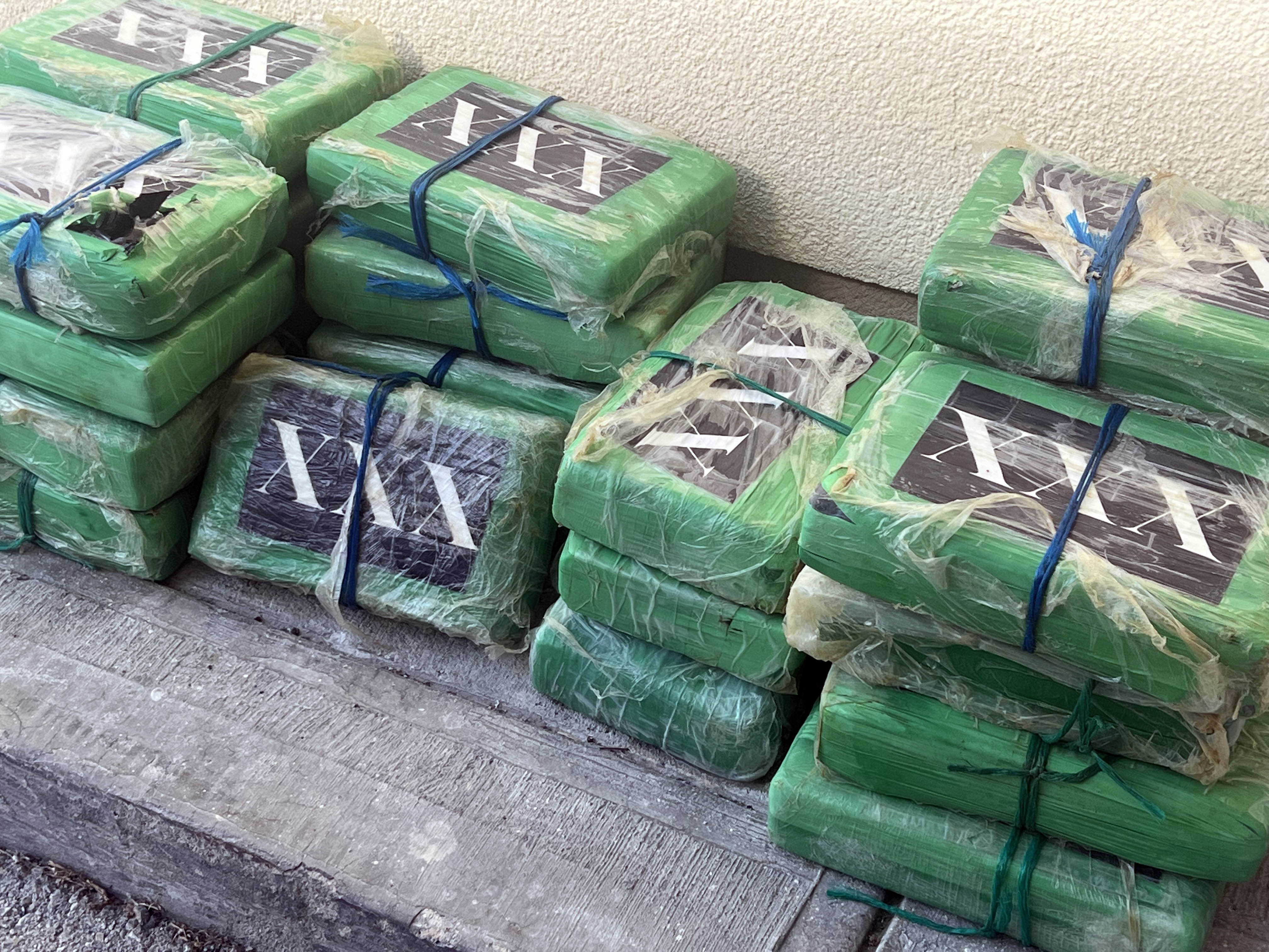 bricks of cocaine with XXX decals on them wrapped in green