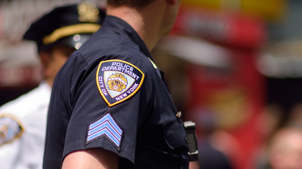 An NYPD officer is shown.
