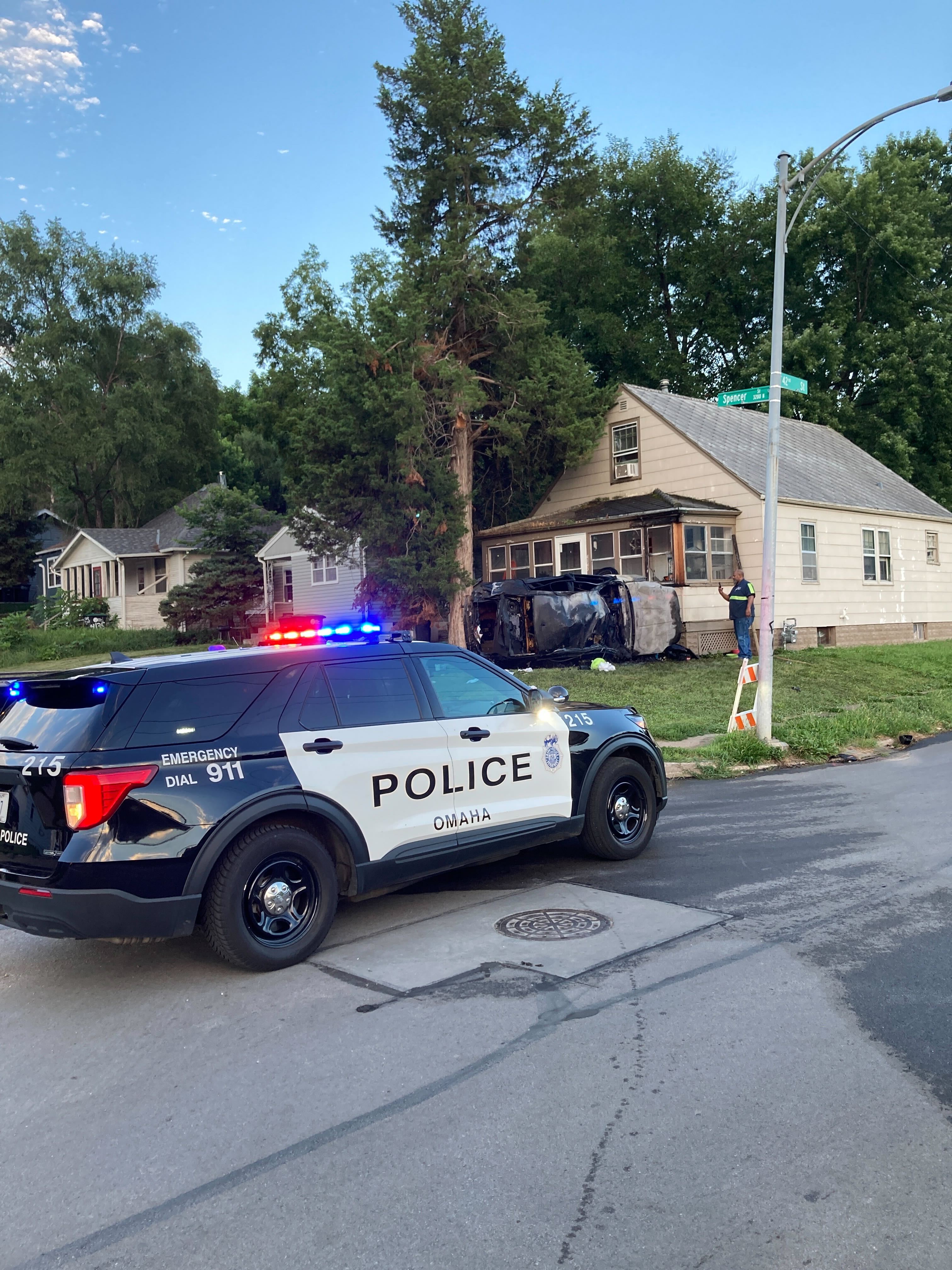 Omaha Police Cruiser with wrecked car at house in background