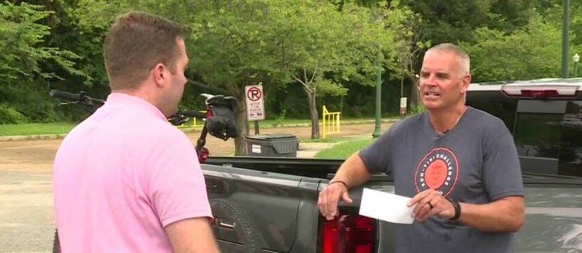 Surprising cyclist with donation for non-profit that supports those with disabilities through sports
