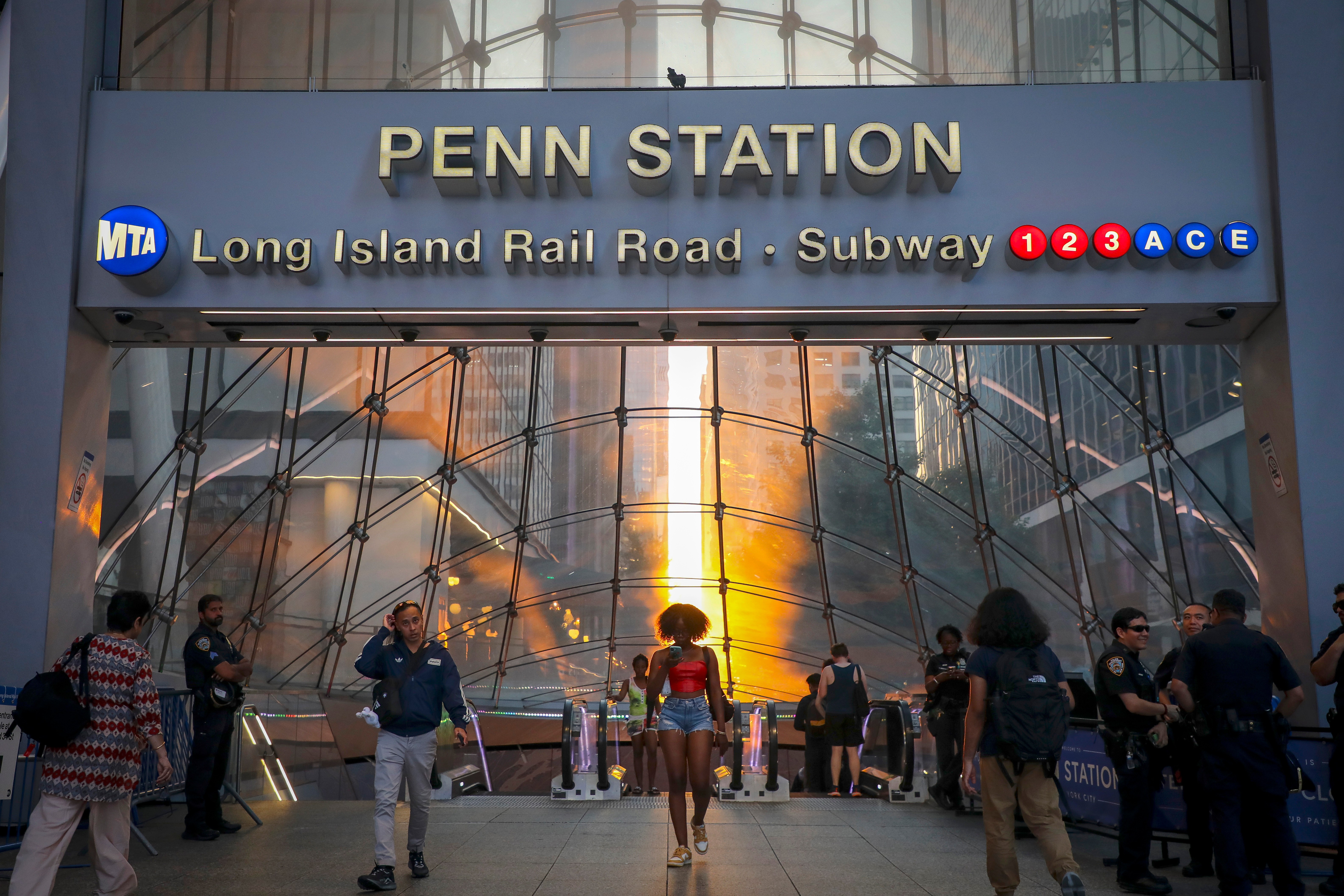 FILE - Commuters pass Penn Station and Madison Square Garden, July 2, 2026, in New York. 