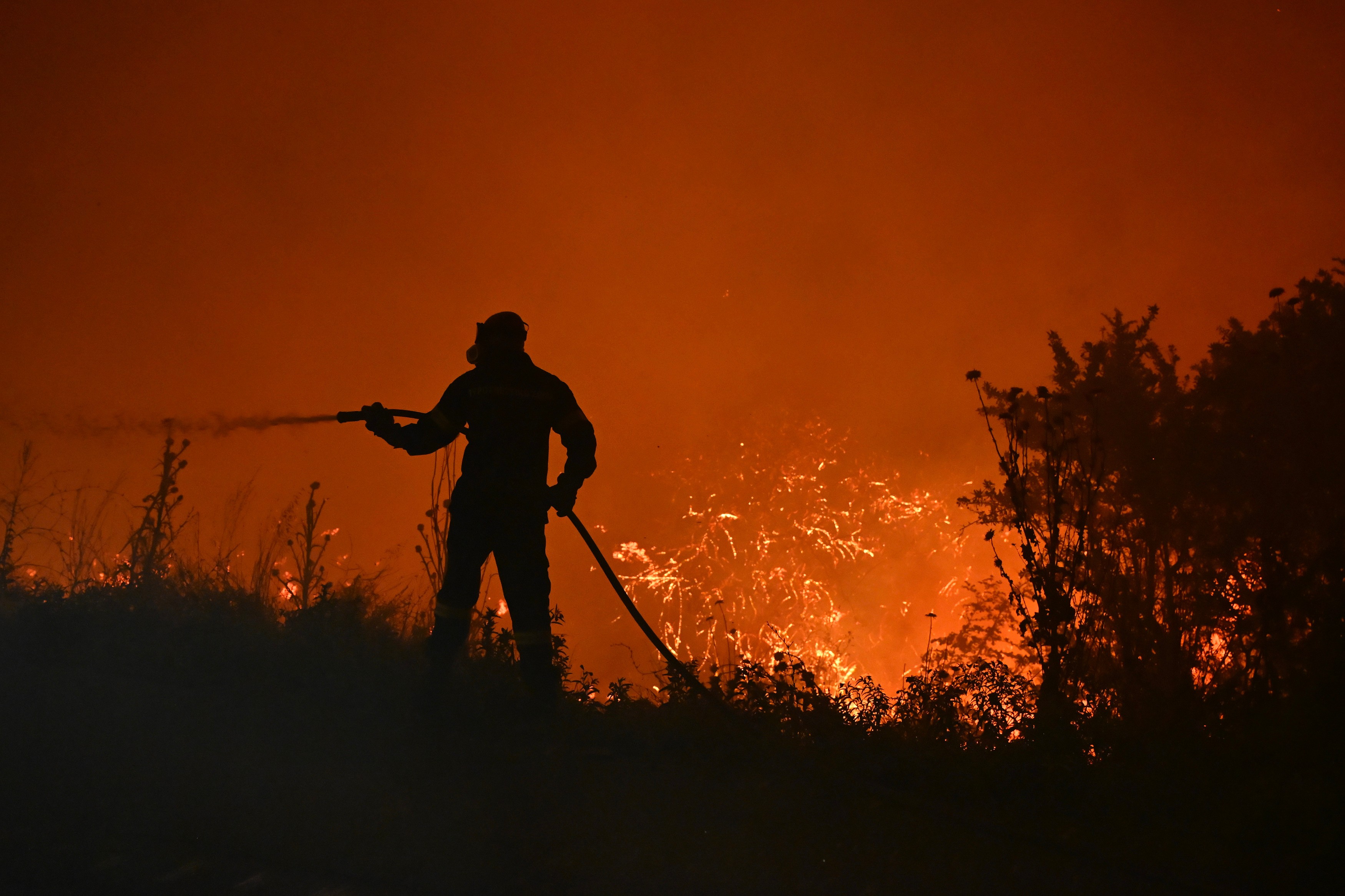 A firefighter works on a wildfire on the outskirts of the northern city of Thessaloniki, Greece, Sunday, July 5, 2026.