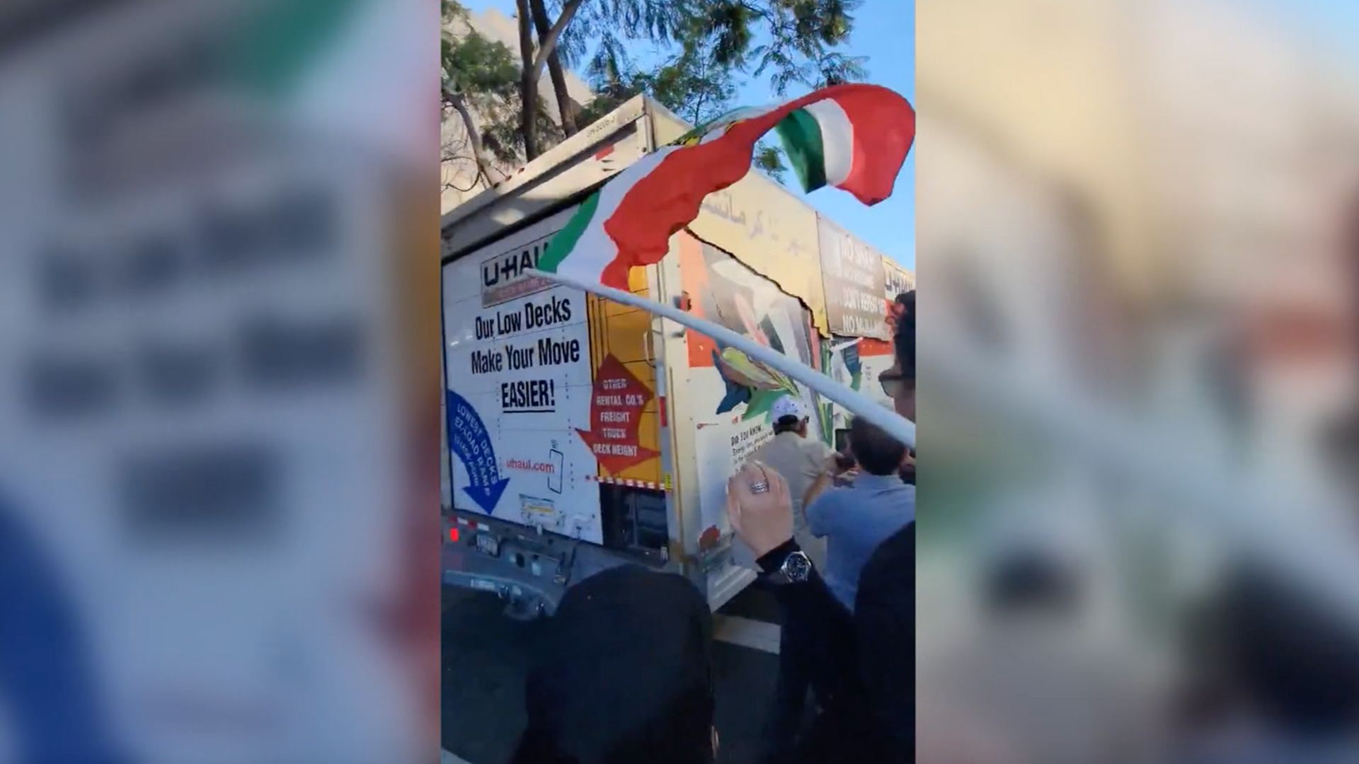 This screenshot from a video shows a U-Haul truck driving through an anti-Iran protest in downtown Los Angeles.