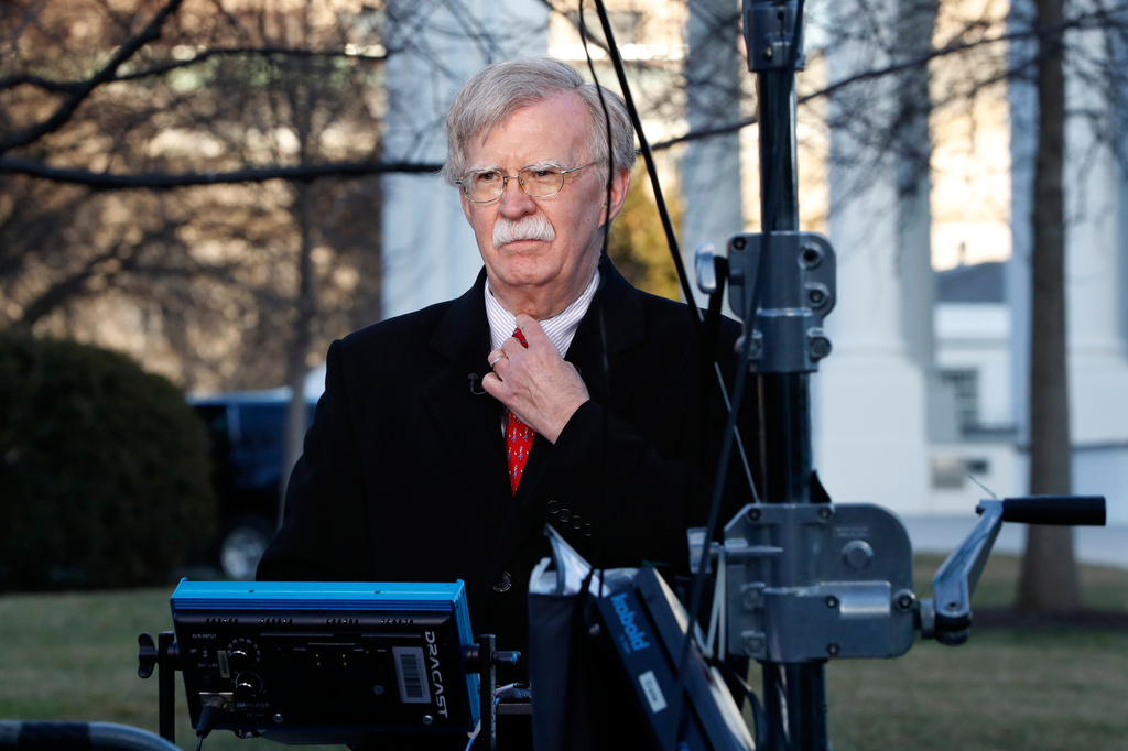 Former national security adviser John Bolton straightens his tie before an interview, March 5, 2019, at the White House in Washington.