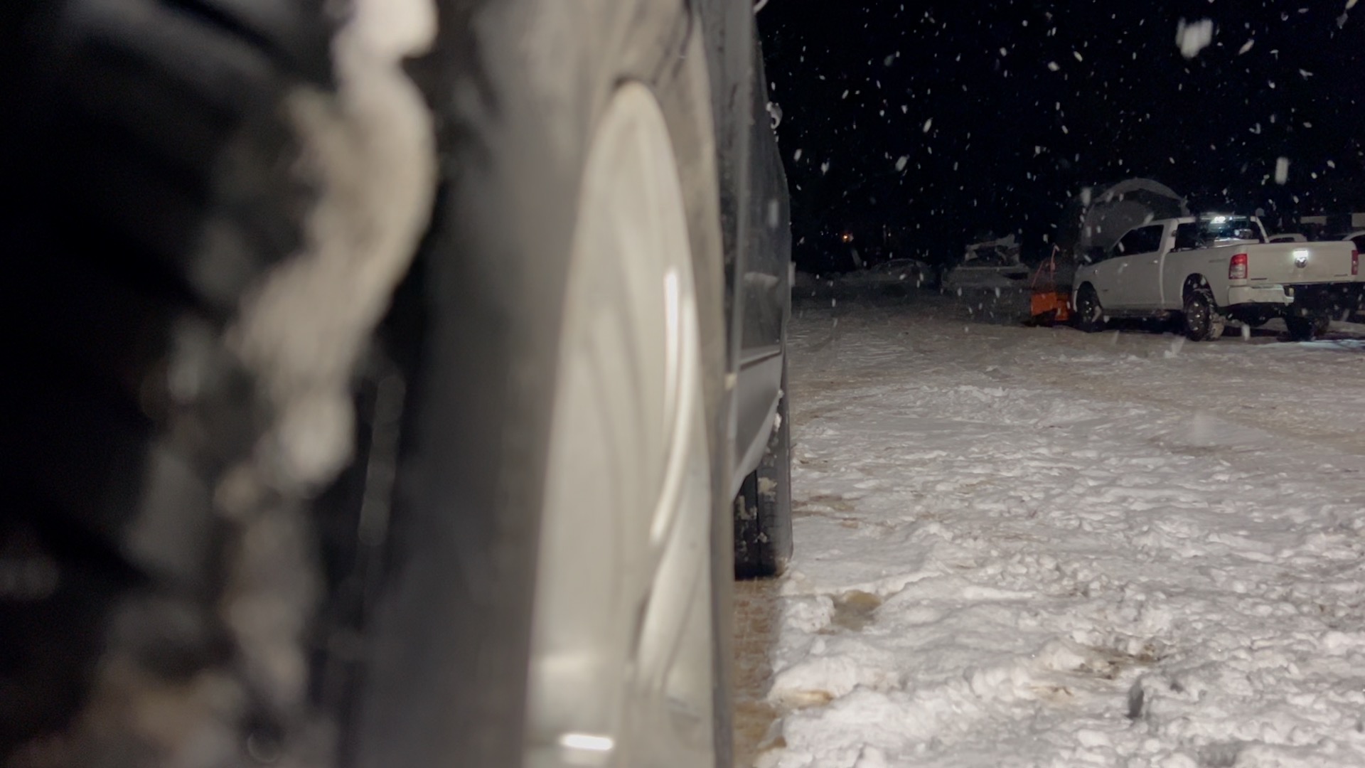 Tire in front with snow plow in background
