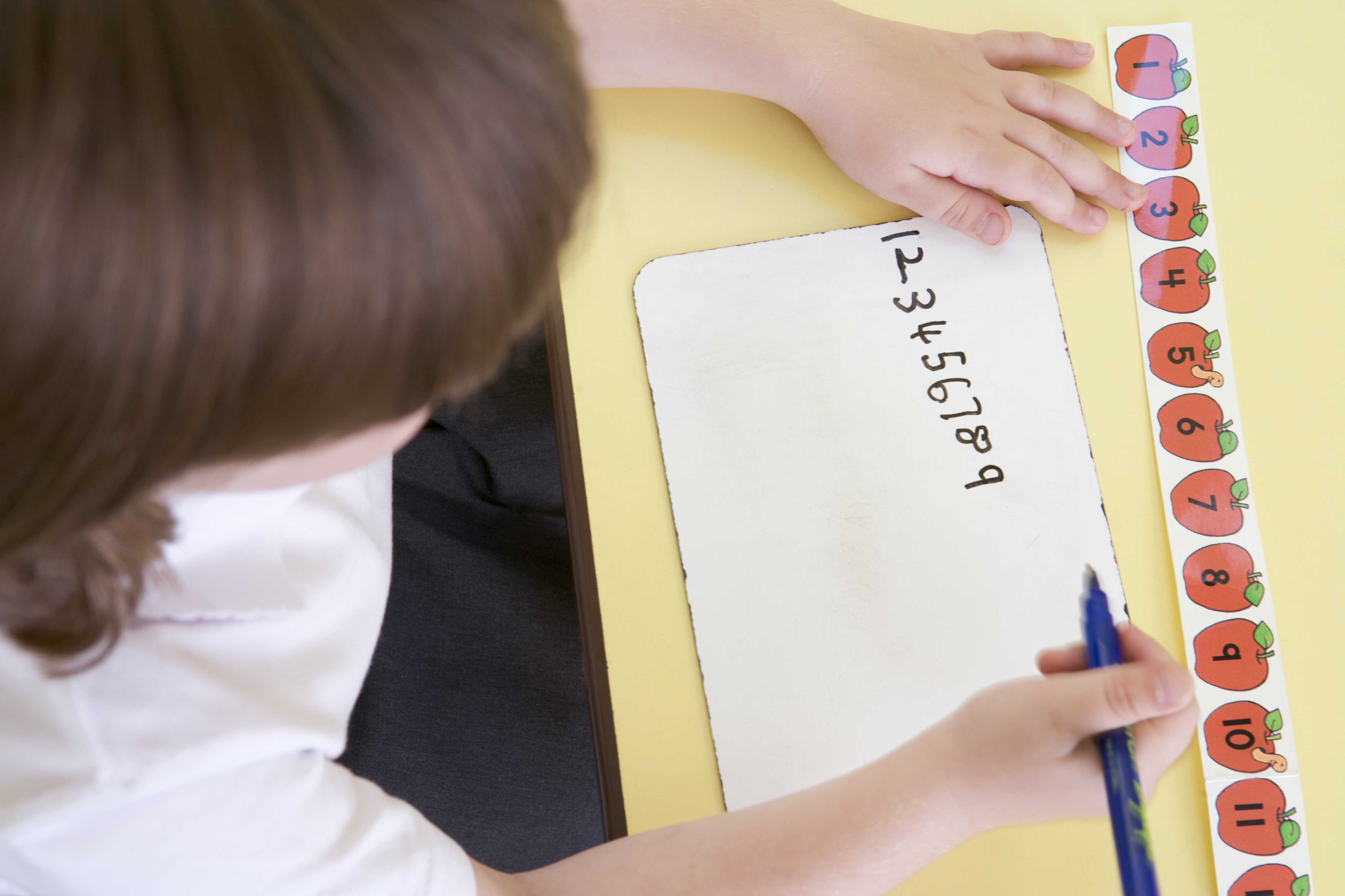 Girl learning to write numbers in primary class