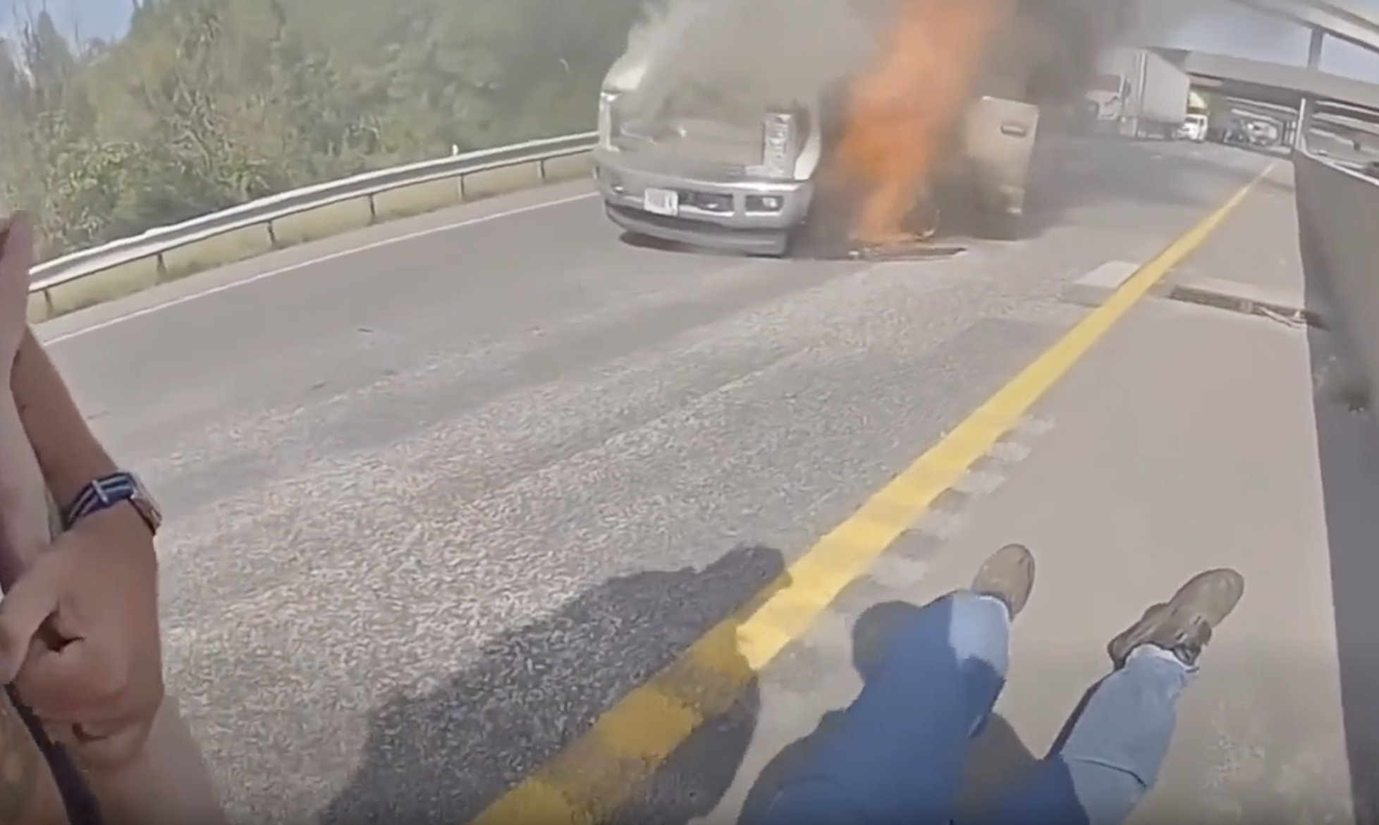 Law enforcement officers rescue a man from a burning truck. 