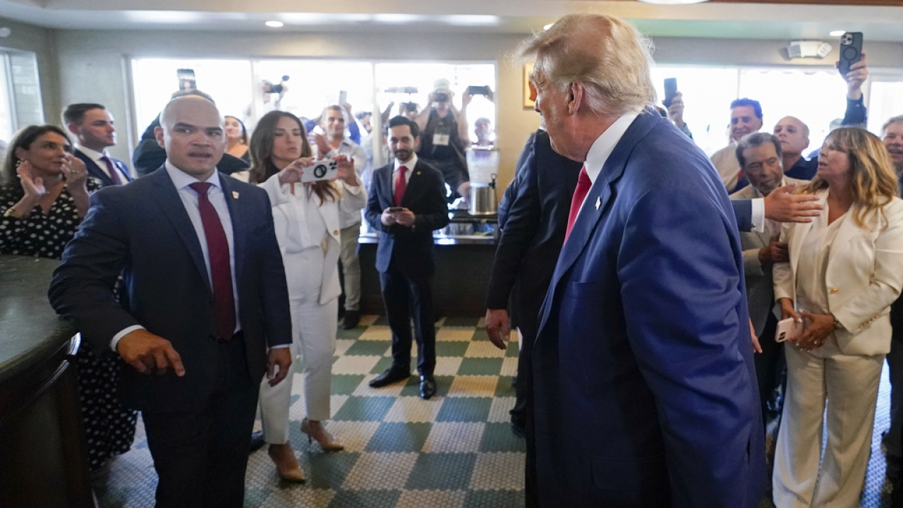 Former President Donald Trump looks to his valet Walt Nauta at Versailles restaurant.