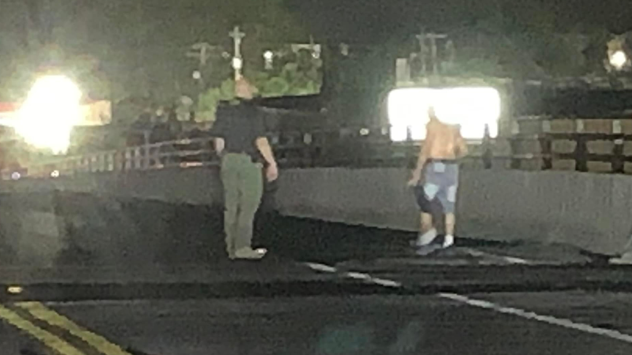 Martin County Chief Deputy John Budensiek speaks to a man on the Martin Highway overpass bridge on March 19, 2022.jpg