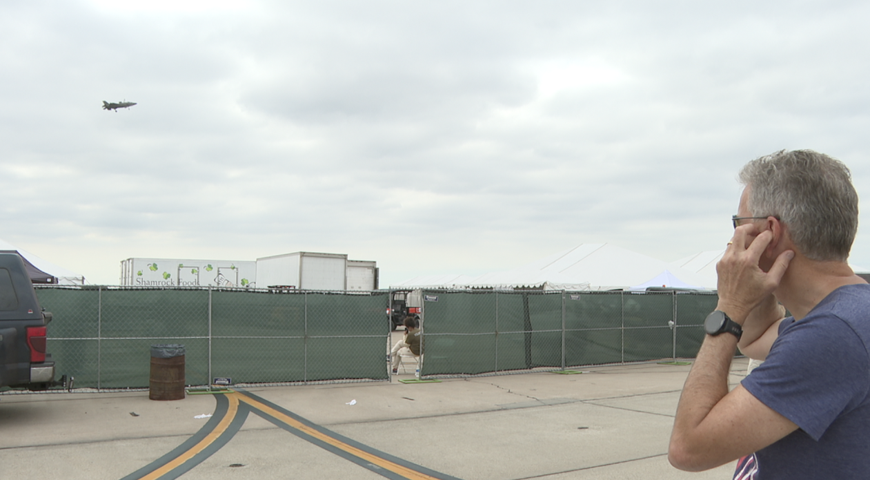 Burton Kloster is plugging his ears because of the noise, but that didn't stop him from sharing his pride in the military's advancements in technology. 