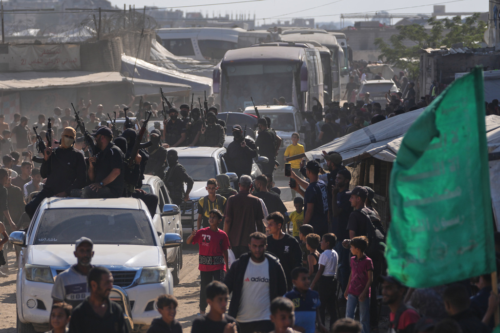Hamas gunmen escort buses carrying freed Palestinian prisoners arriving in the Gaza Strip after their release from Israeli jails under a ceasefire agreement between Hamas and Israel, in Khan Younis, southern Gaza Strip, Monday, Oct. 13, 2025. 