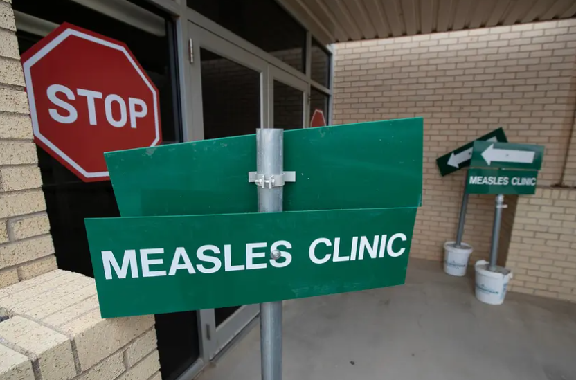 Signs let people know that measles vaccines are available at the old City Hall in Andrews.png