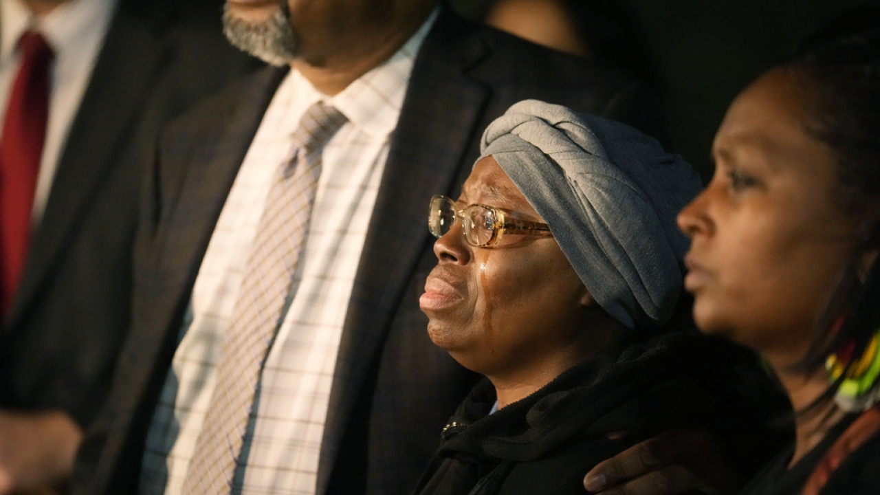 Sheneen McClain, center, is consoled by Omar Montgomery, president of the Aurora NAACP.