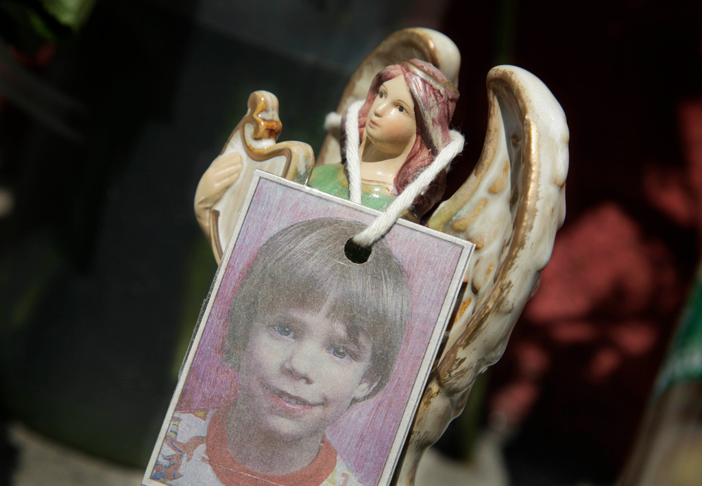 A photograph of Etan Patz hangs on an angel figurine at a makeshift memorial, May 28, 2012, in the Manhattan borough of New York. 