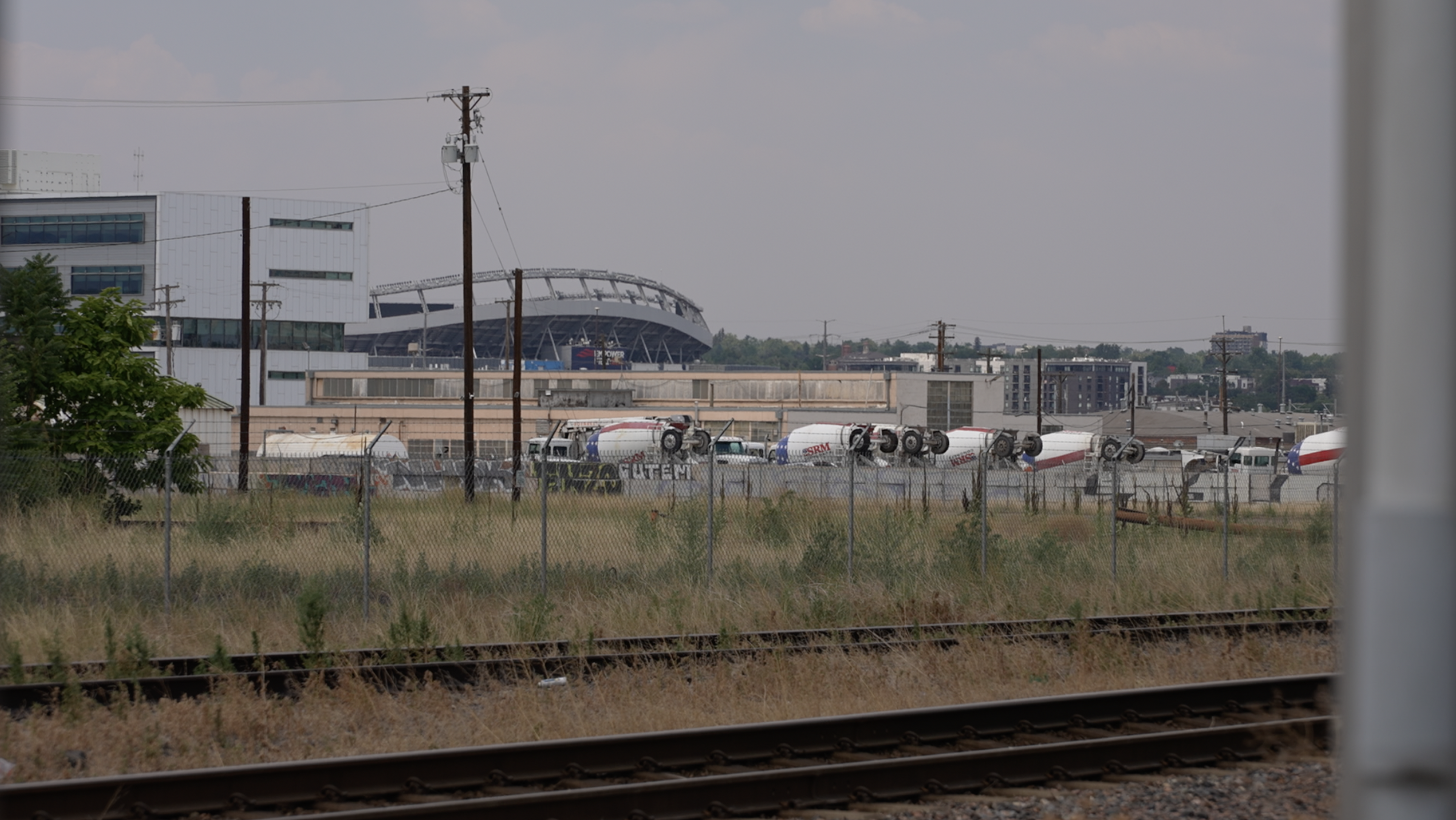 The Burnham Yard site sits empty with the Broncos' current home, Empower Field at Mile High, standing in the distance.