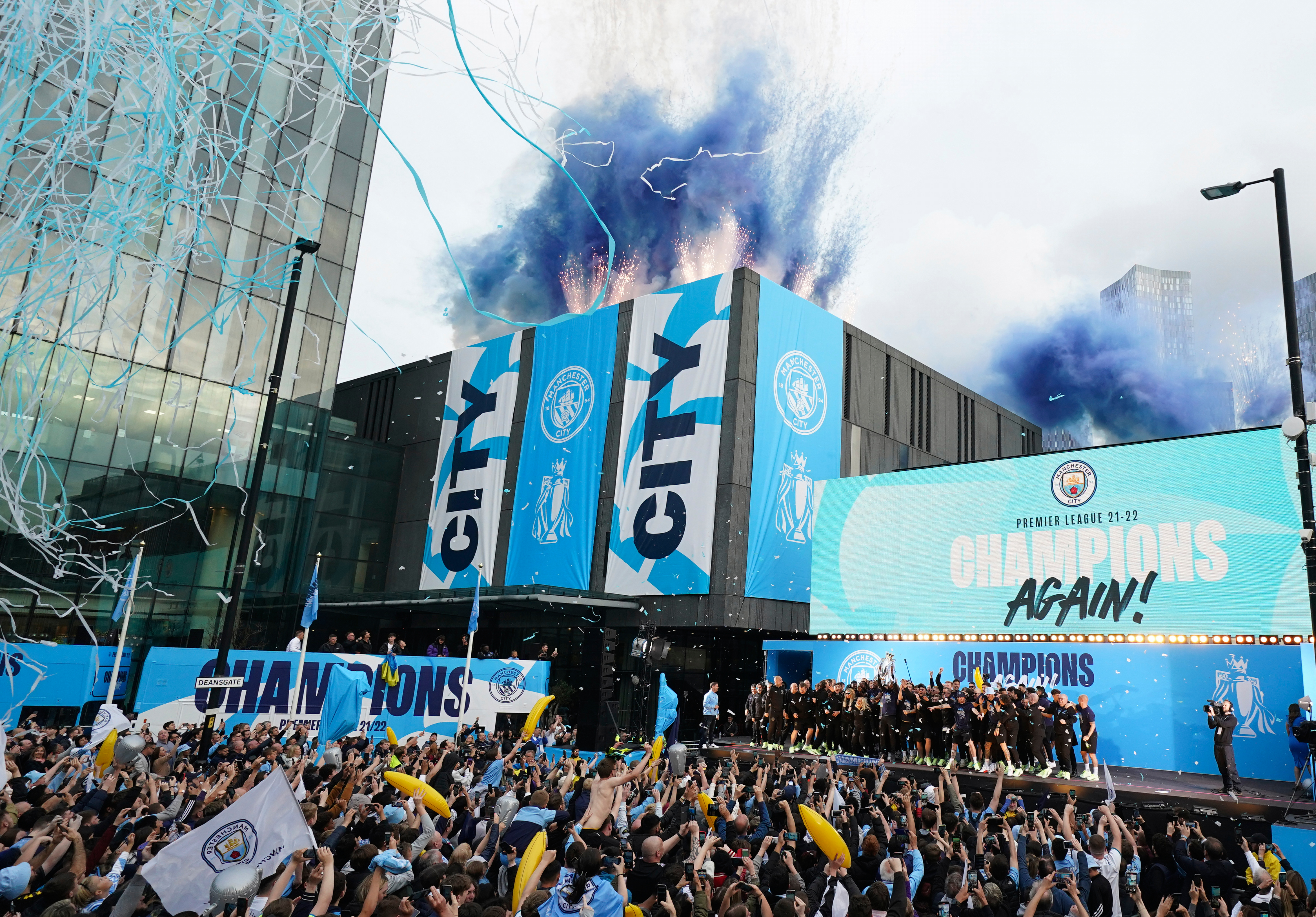 FILE - Flares and tape are let off as Manchester City's players celebrate on stage as fans watch the winners parade as the team celebrates winning the English Premier League title in Manchester, England, Monday, May 23, 2022. 