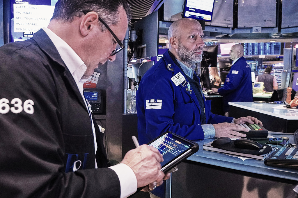 Trader Edward Curran, left, and specialist Meric Greenbaum, center, work on the floor of the New York Stock Exchange, Friday, May 22, 2026.