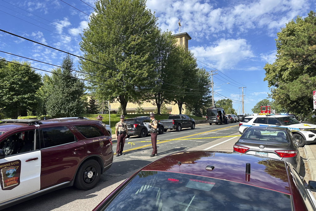 Law enforcement officers gather outside the Annunciation Church's school in response to a reported mass shooting, Wednesday, Aug. 27, 2025, in Minneapolis. 