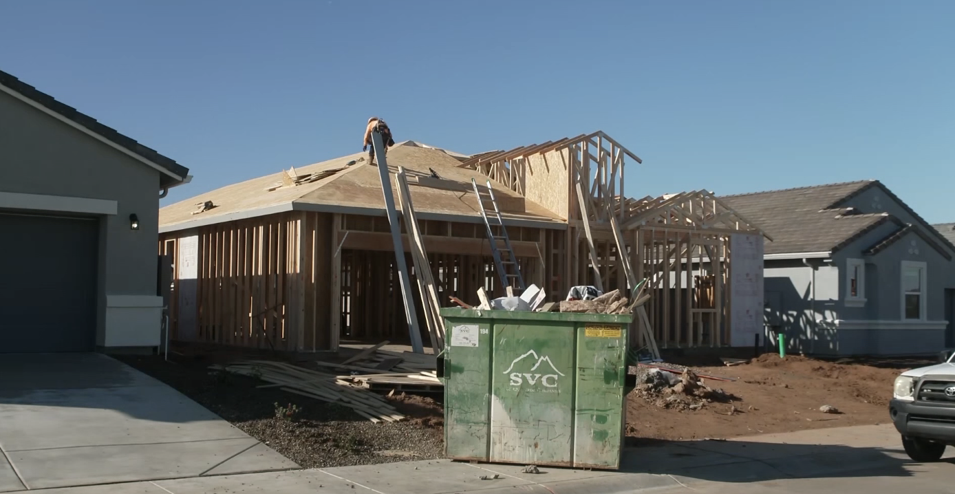 A construction worker on the roof of a house