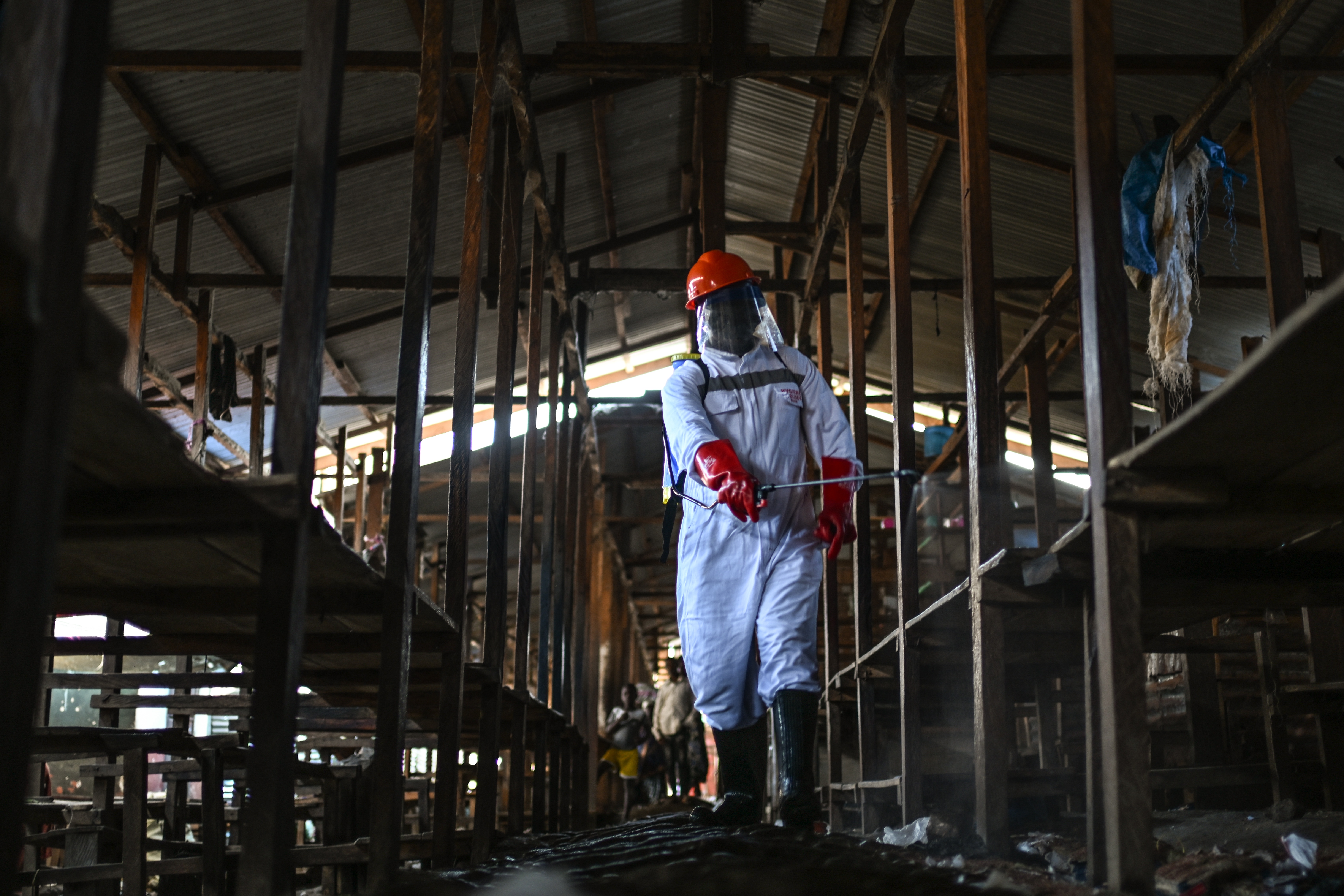 A sanitation worker from the Bunia city government sprays chlorine to disinfect the central market, as Ituri province continues to combat an Ebola outbreak, in Bunia, Congo, Saturday, May 23, 2026. 