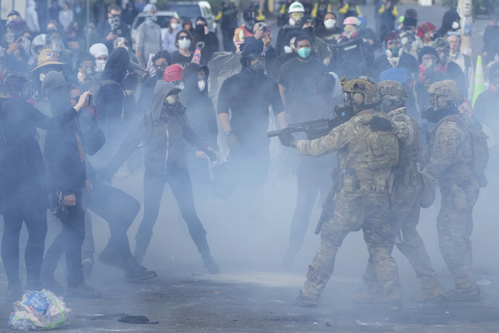 U.S. Customs and Border Protection agents standoff against demonstrators as tear gas fills the air outside the U.S. Immigration and Customs building during a protest Saturday, June 14, 2025, in Portland, Ore.