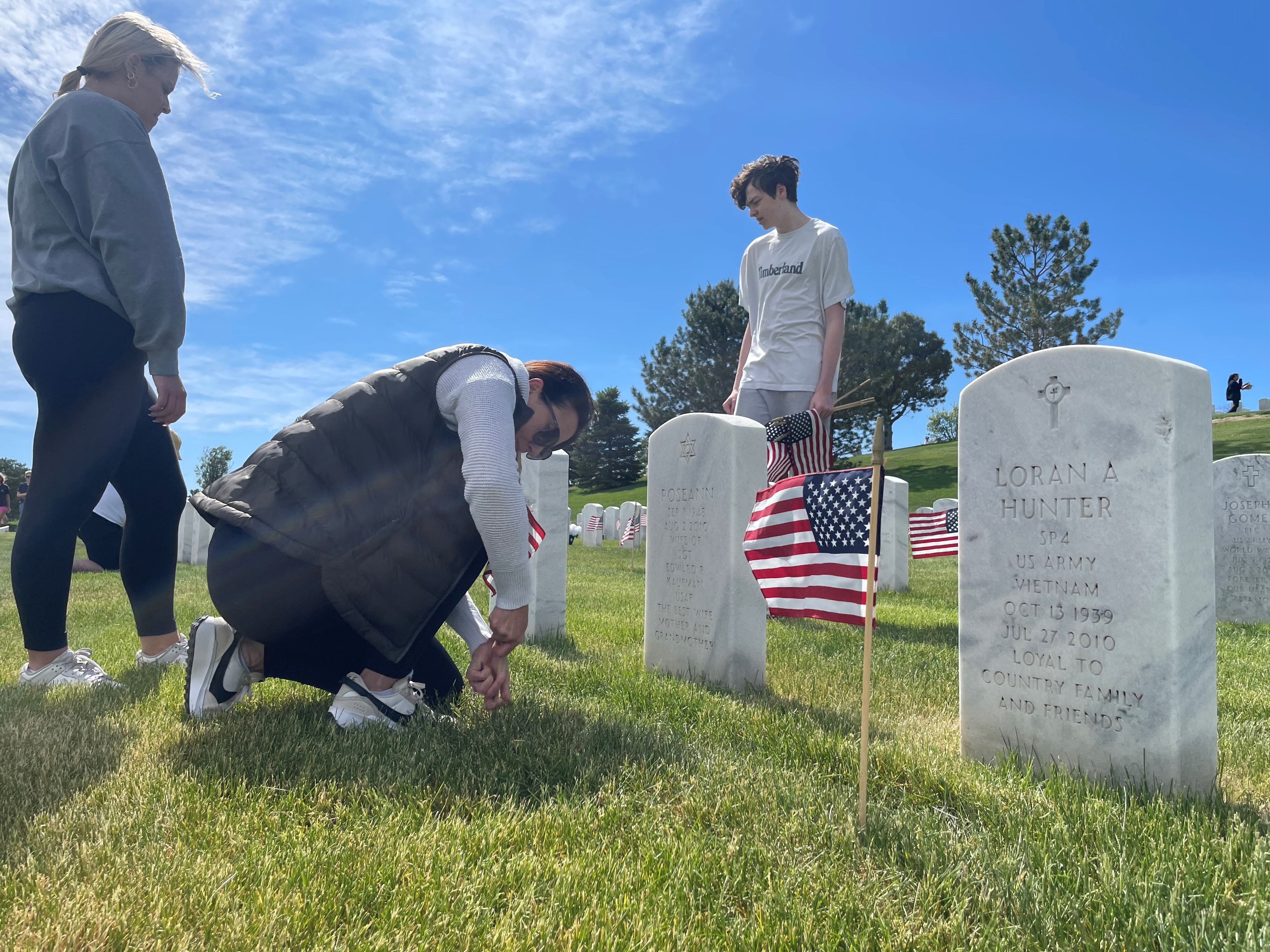 Thousands of volunteers placed American flags on the graves of veterans at Fort Logan National Cemetery.