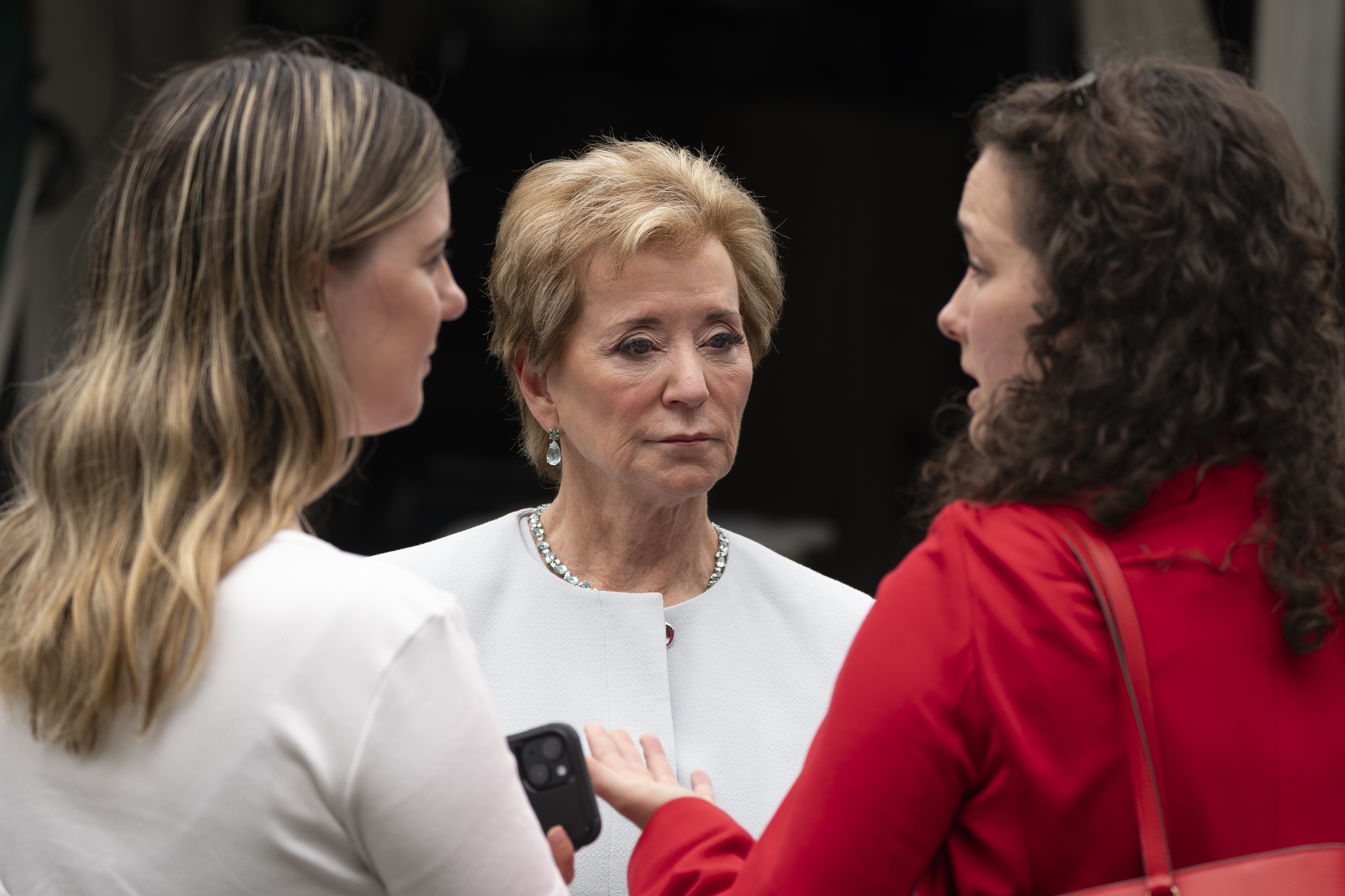 Education Secretary Linda McMahon, talks to her staff as they wait on the North Lawn of the White House for a TV interview, Tuesday, July 15, 2025. 