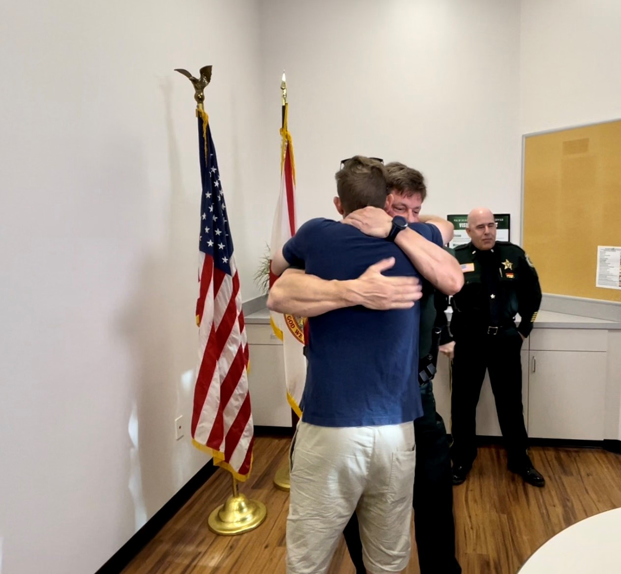 Palm Beach County Deputy Karl Chaikin hugs David Bradley