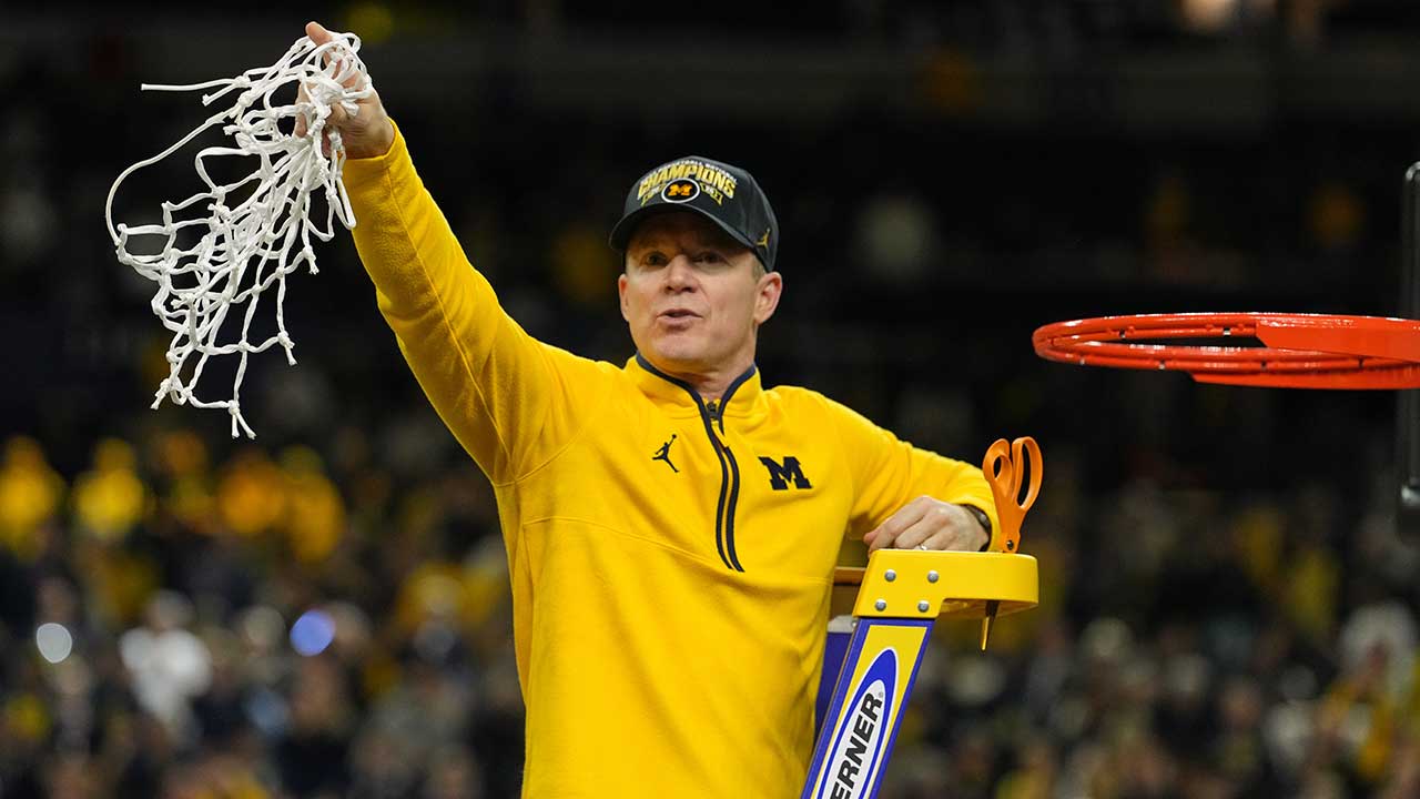 FILE - Michigan head coach Dusty May celebrates by cutting down the net after defeating UConn in the NCAA college basketball tournament national championship game at the Final Four, April 6, 2026, in Indianapolis.