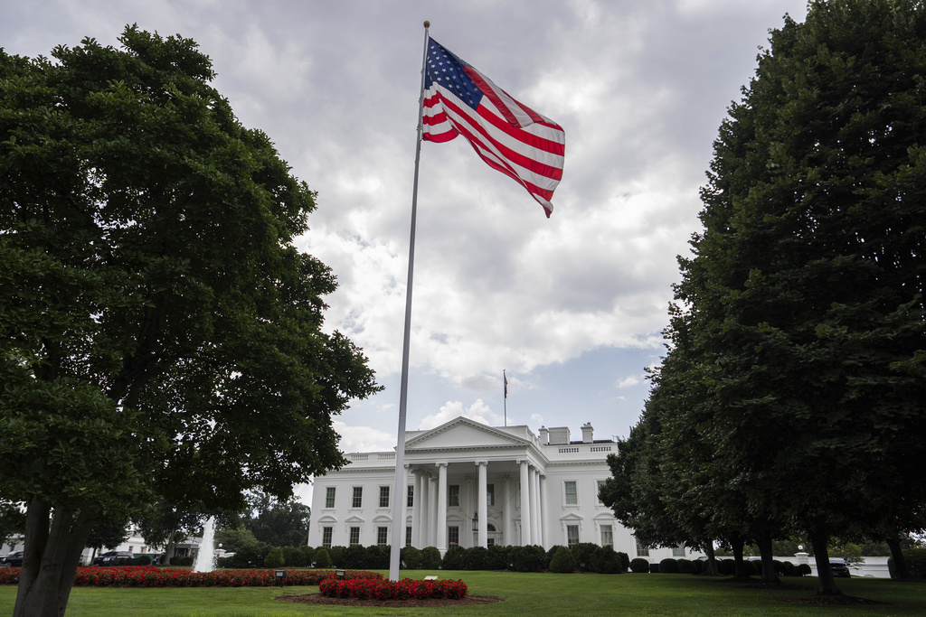 An American flag flies in front of the White House.