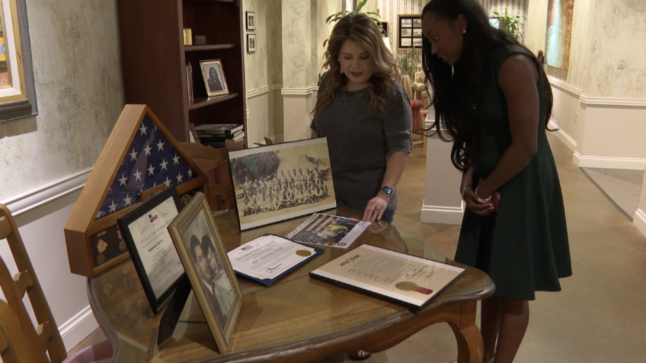 Granddaughter signaling to a table of memories commemorating her grandfather, Florencio Davila.