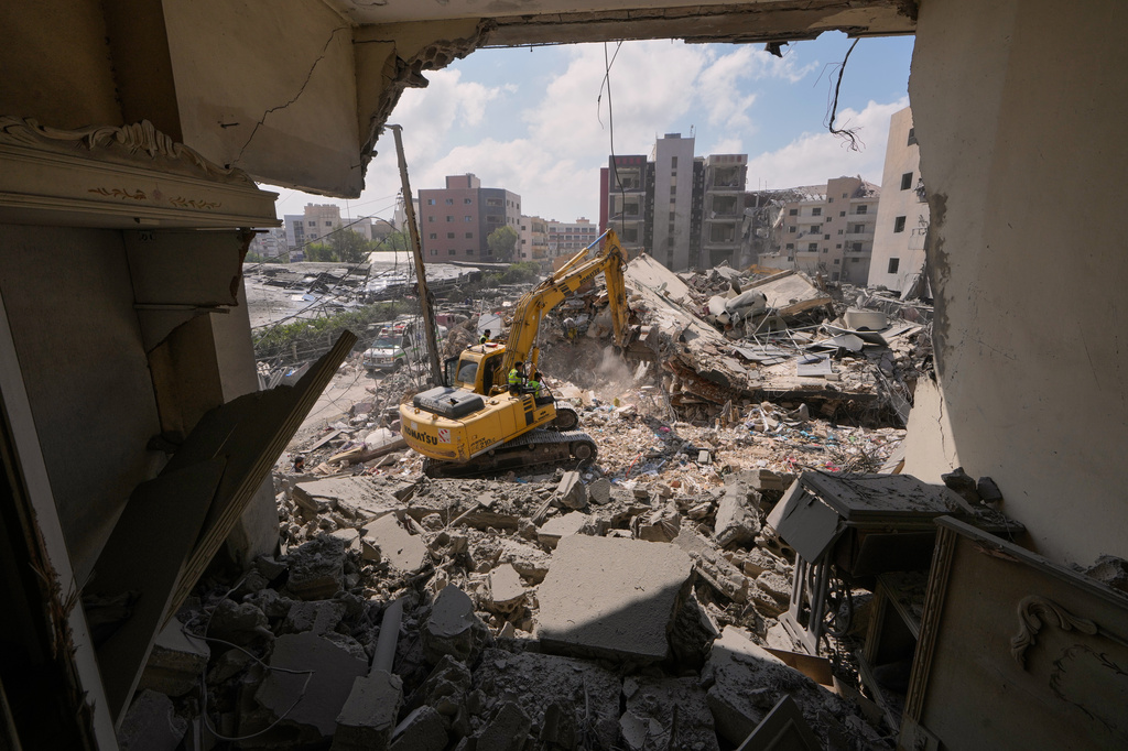 Rescue workers use an excavator, as they search for victims under the rubble of a building that was hit Monday in an Israeli airstrike in the southern port city of Tyre, Lebanon, Tuesday, June 2, 2026. 
