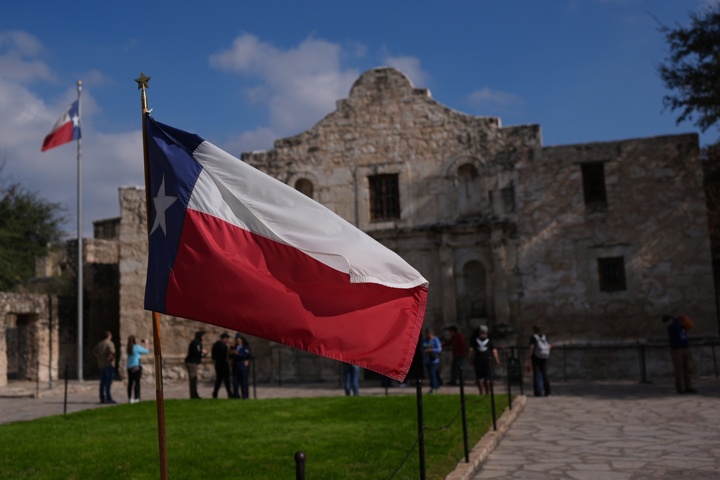 The Texas flag stands in front of the Alamo, Thursday, Jan. 22, 2026, in San Antonio.