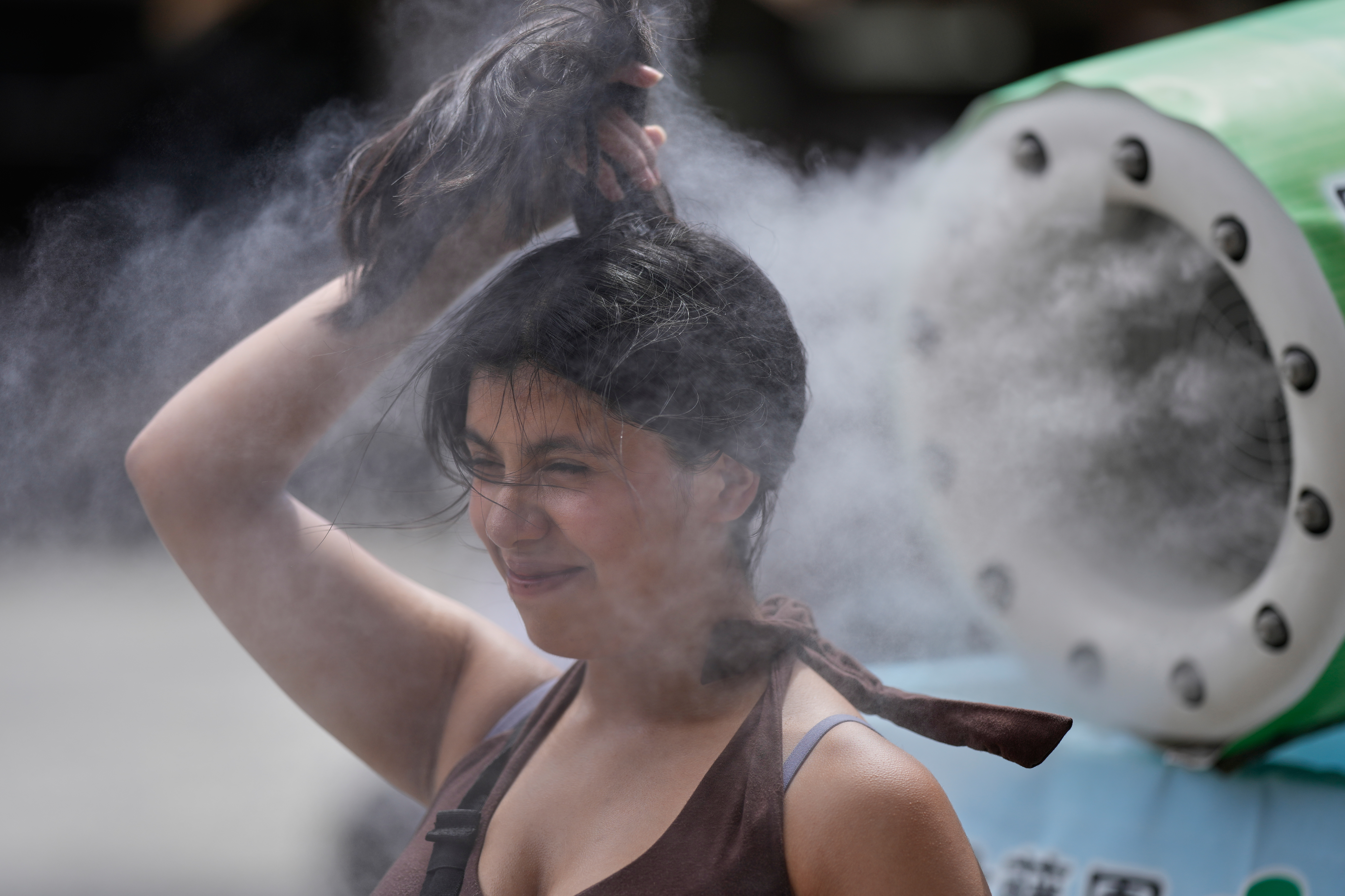 A person cools off at a cooling mist spot on a hot and sunny day at the Sensoji Buddhist temple in Tokyo's Asakusa district on Aug. 7, 2026. 