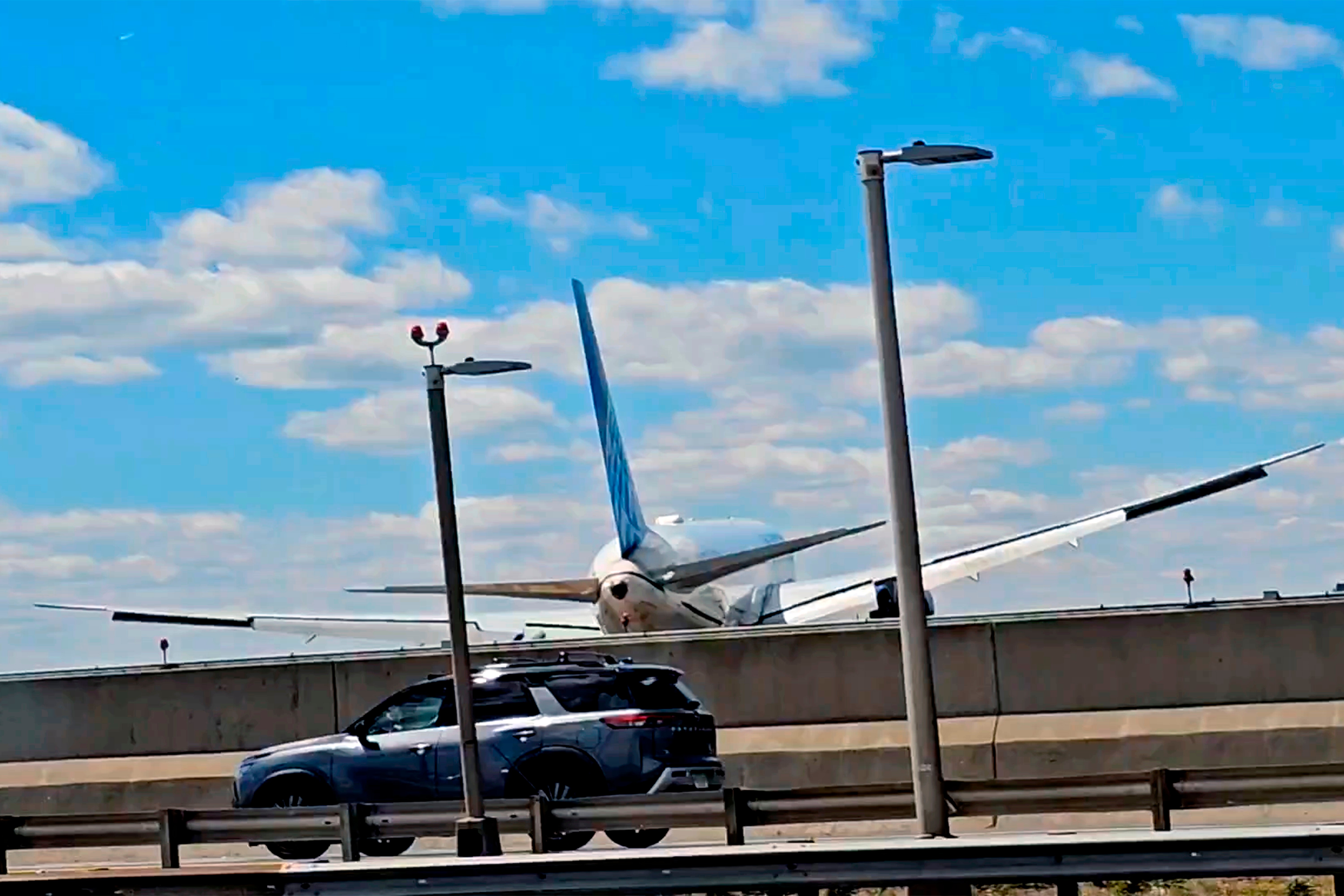 A United Airlines plane is seen in a still image taken from video after hitting a light pole on the New Jersey Turnpike as it lands at Newark Liberty International Airport, Sunday, May 3, 2026.
