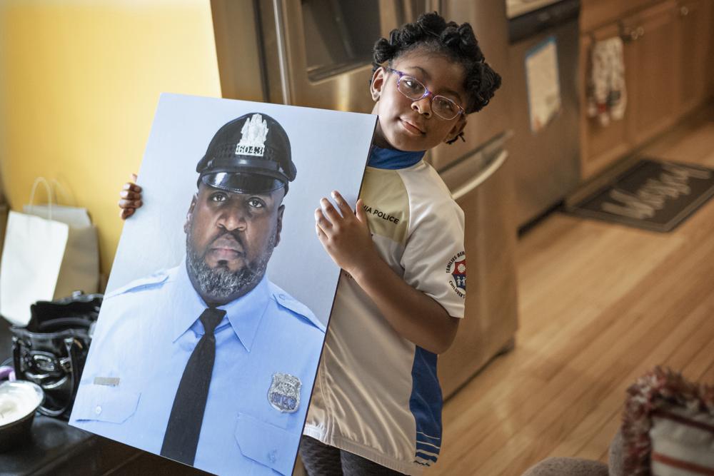 Amethyst, Erin "Toke" Tokley's five year old daughter, holds a photo of her father