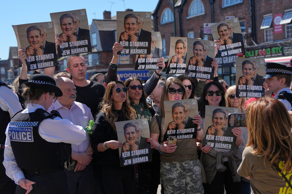 Protesters hold posters near the scene where two people were stabbed yesterday in the Golders Green neighbourhood, that has a large Jewish community, in London, Thursday, April 30, 2026.
