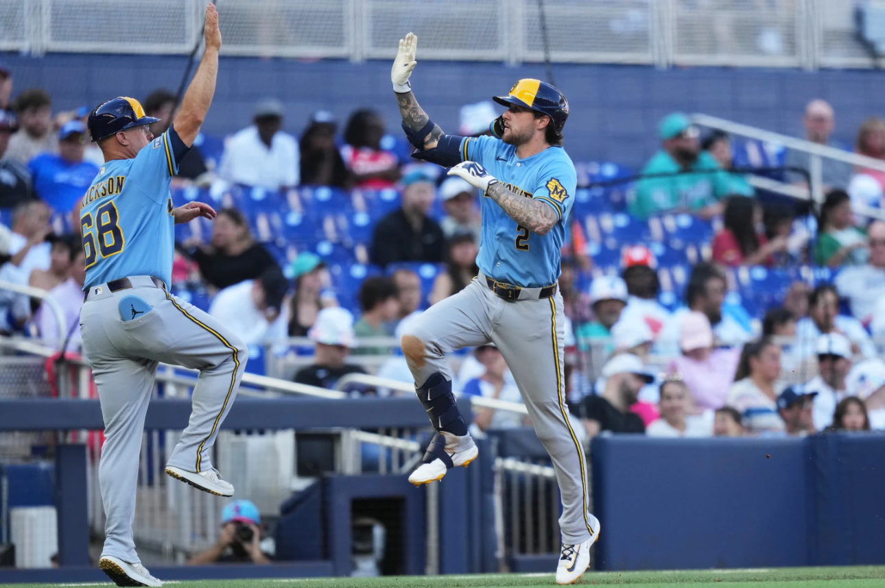 Milwaukee Brewers' Brice Turang (2) is met by third base coach Matt Erickson (68) after hitting a two-run home run during the fifth inning of a baseball game against the Miami Marlins, Saturday, April 18, 2026, in Miami.