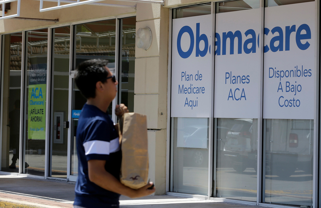 A man walks by an healthcare insurance office in Hialeah, Fla., July 27, 2017.