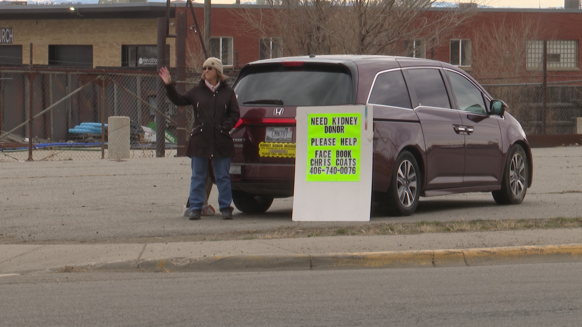 Chris Coats next to her signs on 6th Ave North