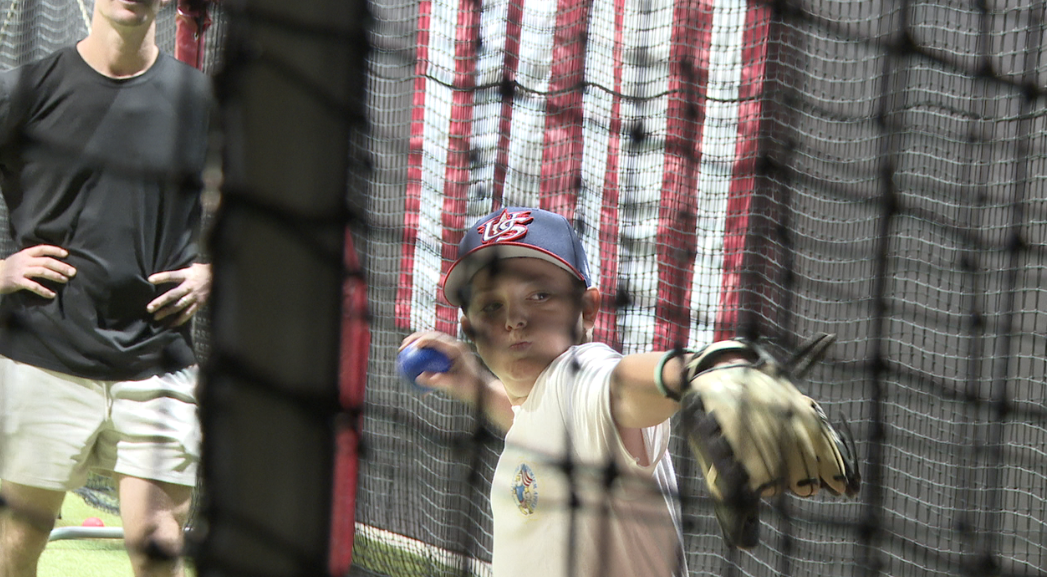 A kid practicing baseball at Roo 21. 