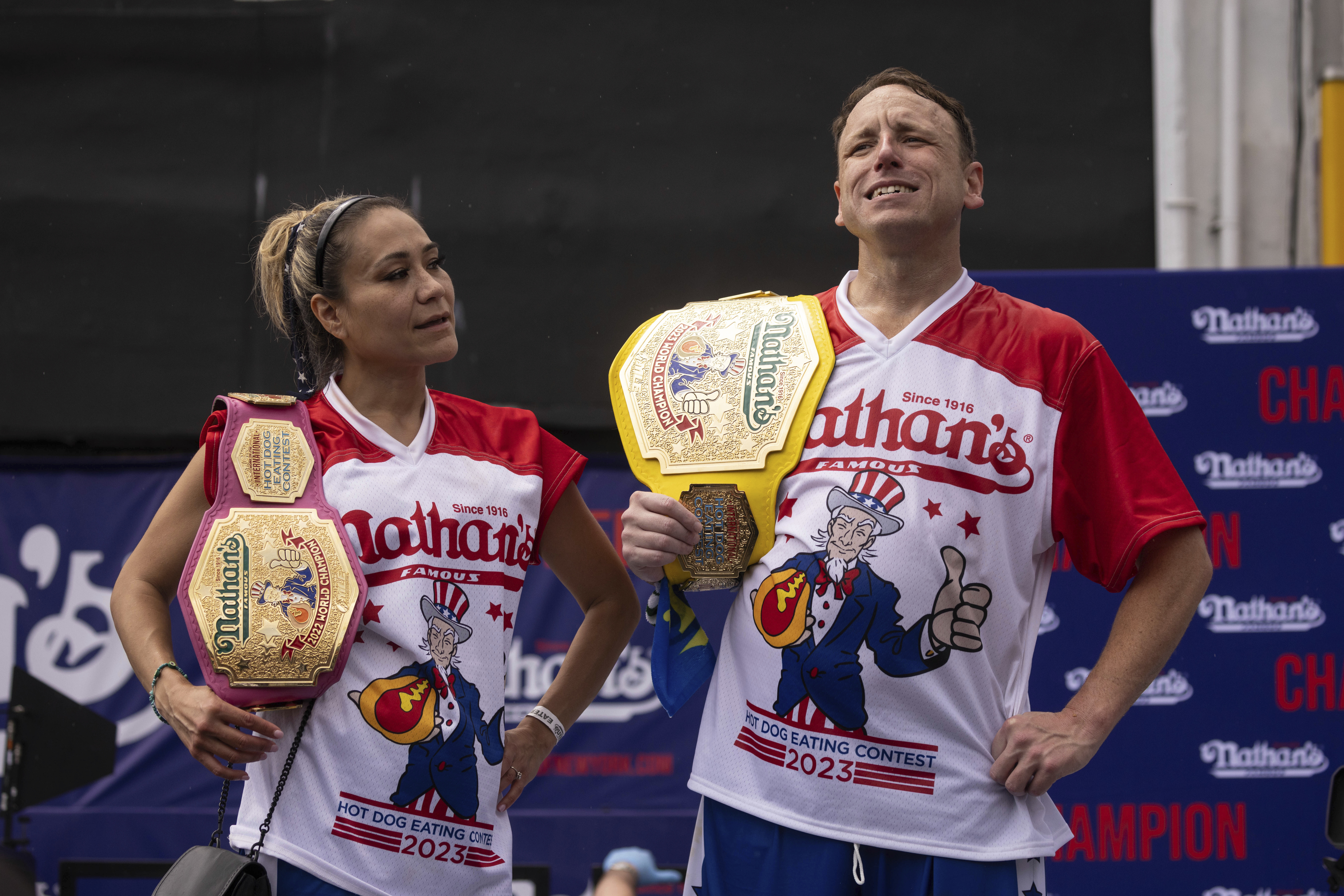 Miki Sudo and Joey Chestnut with championship belts after winning Nathan's Famous hot dog-eating contest, July 4, 2023