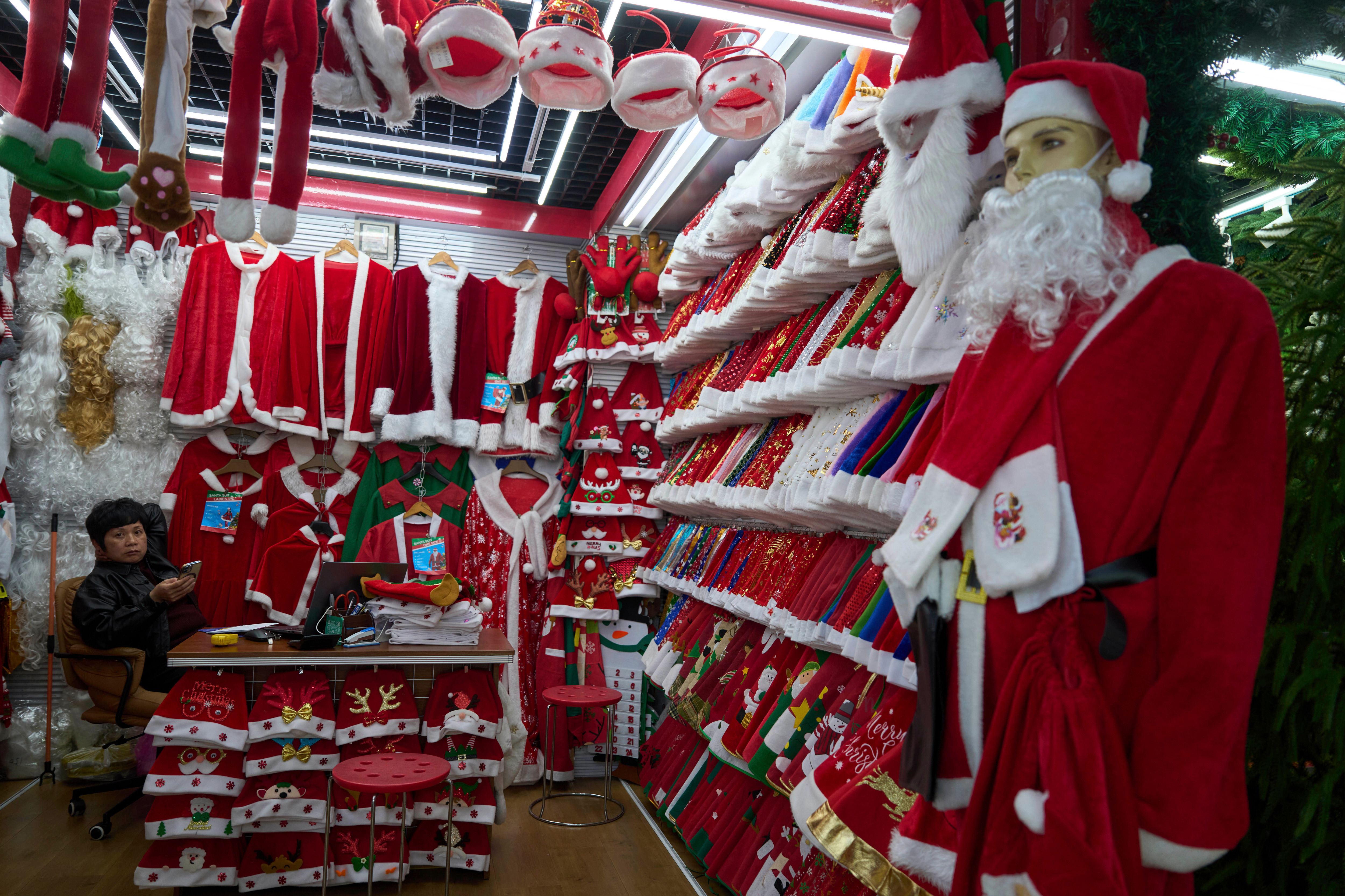 FILE - A vendor waits for customers near Santa costumes for sale at the Yiwu International Trade Market in Yiwu, eastern China's Zhejiang province on April 10, 2025.
